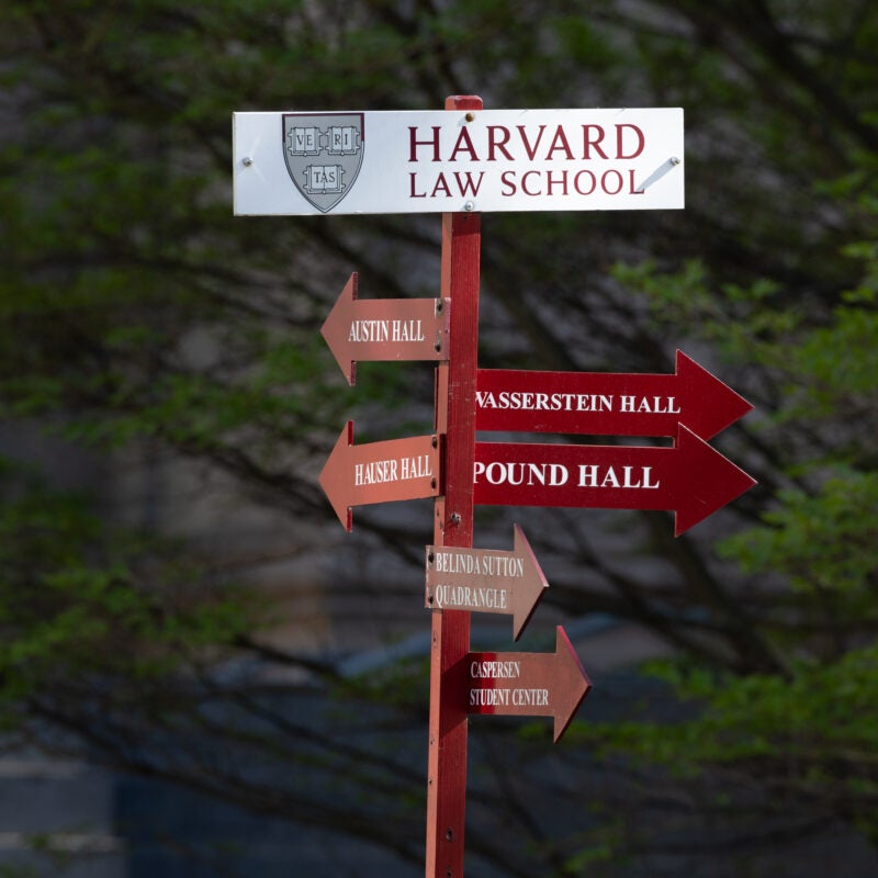 A Harvard Law School sign with arrows pointing to buildings around campus