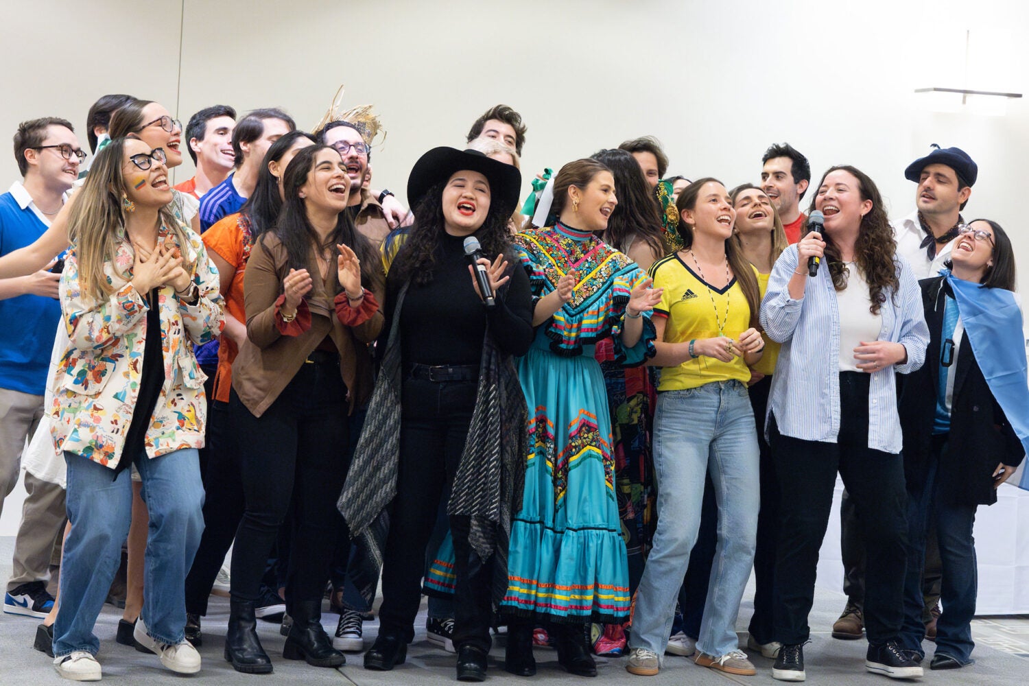 Groups of students gathered on a stage singing.