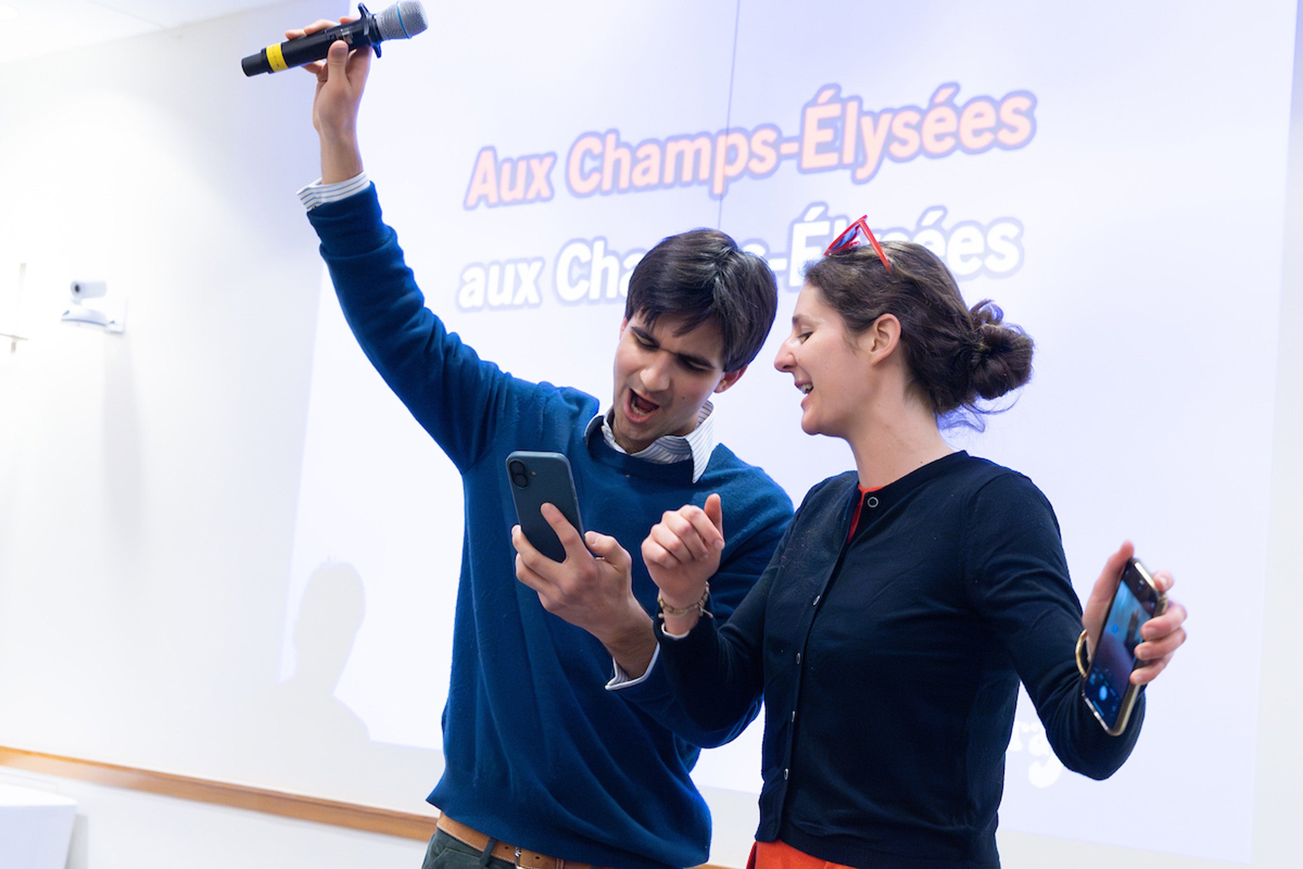 Two students, sing on a stage.