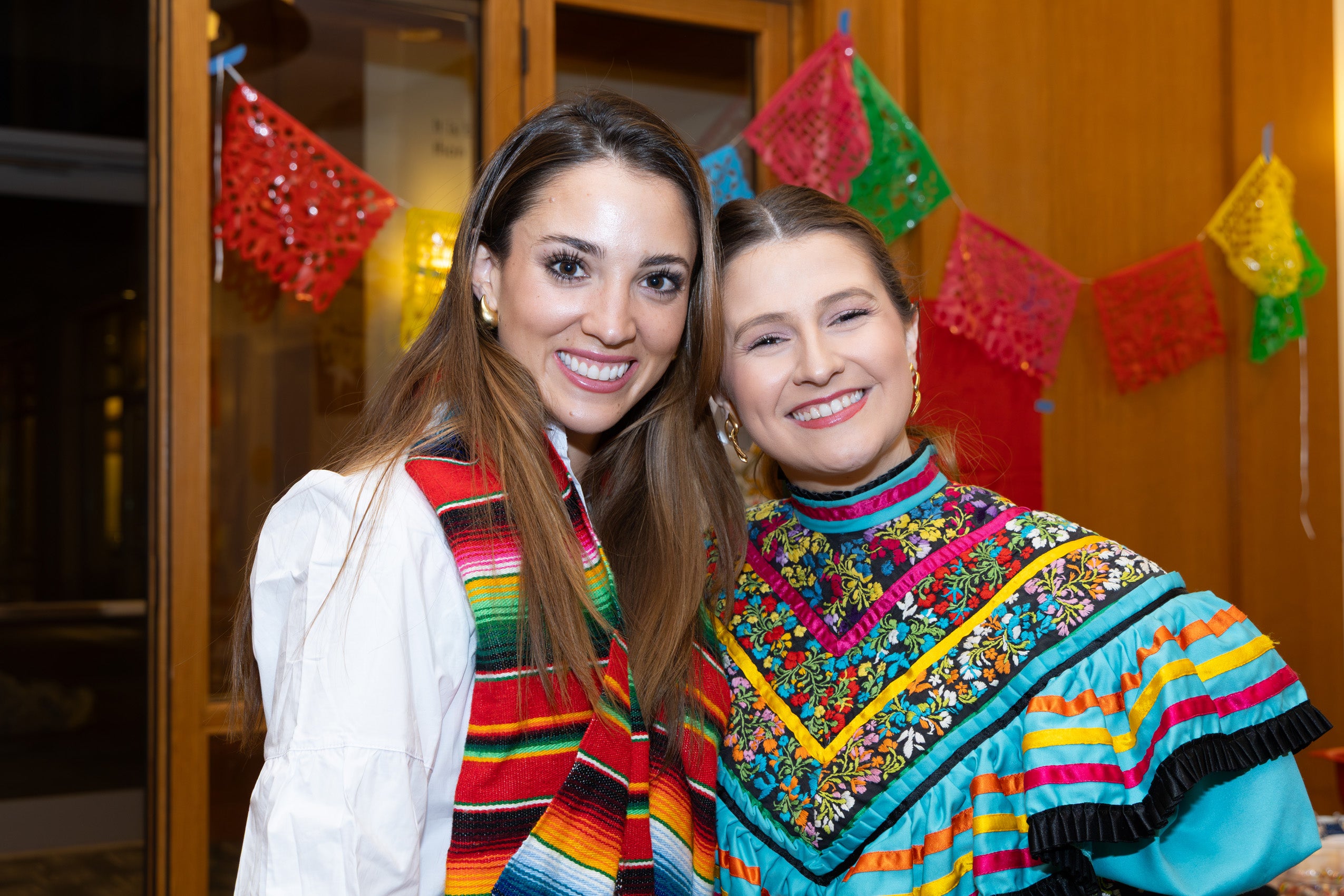 Two students at an event wearing clothing from their homeland.