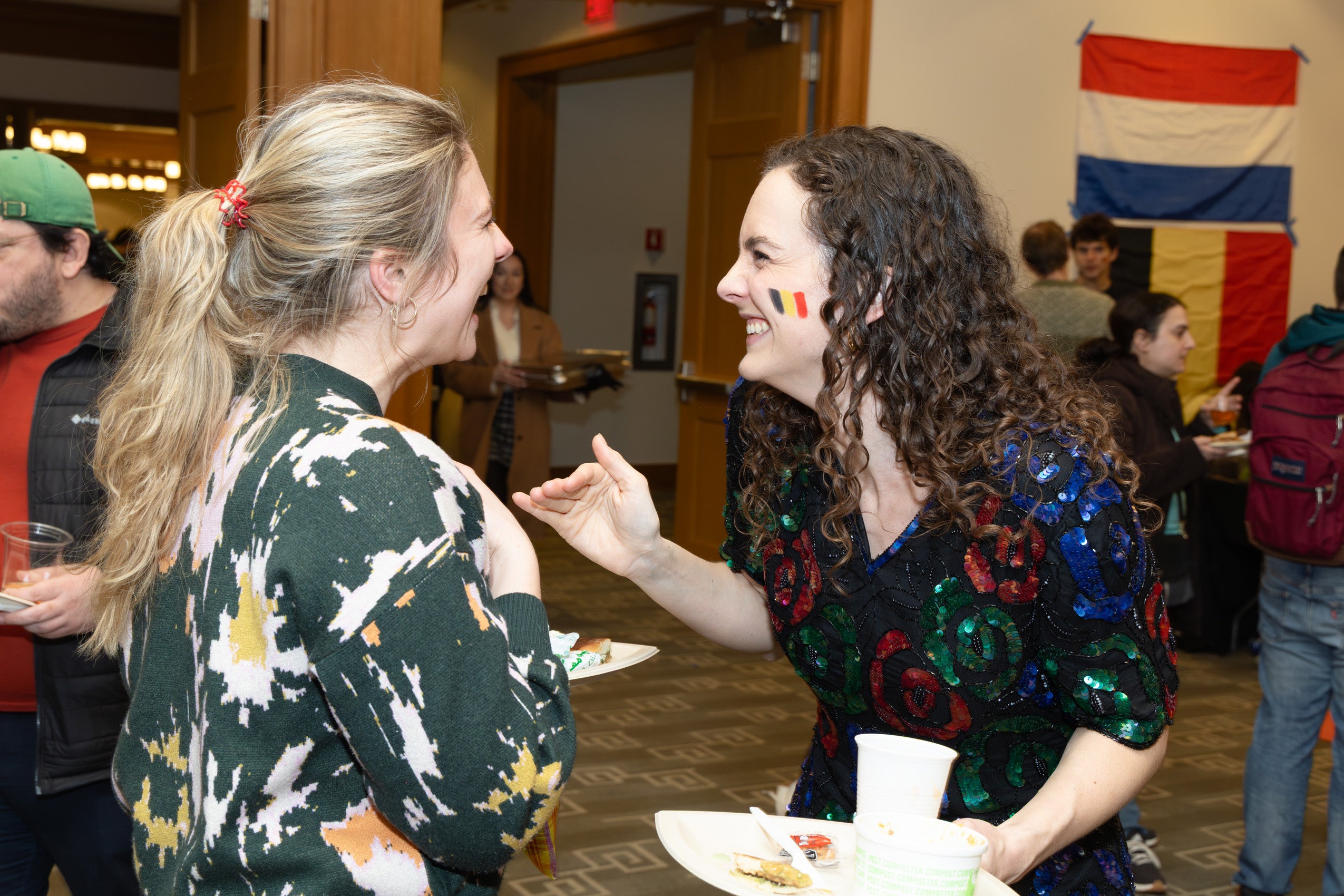 Two women share a fun moment at an event.