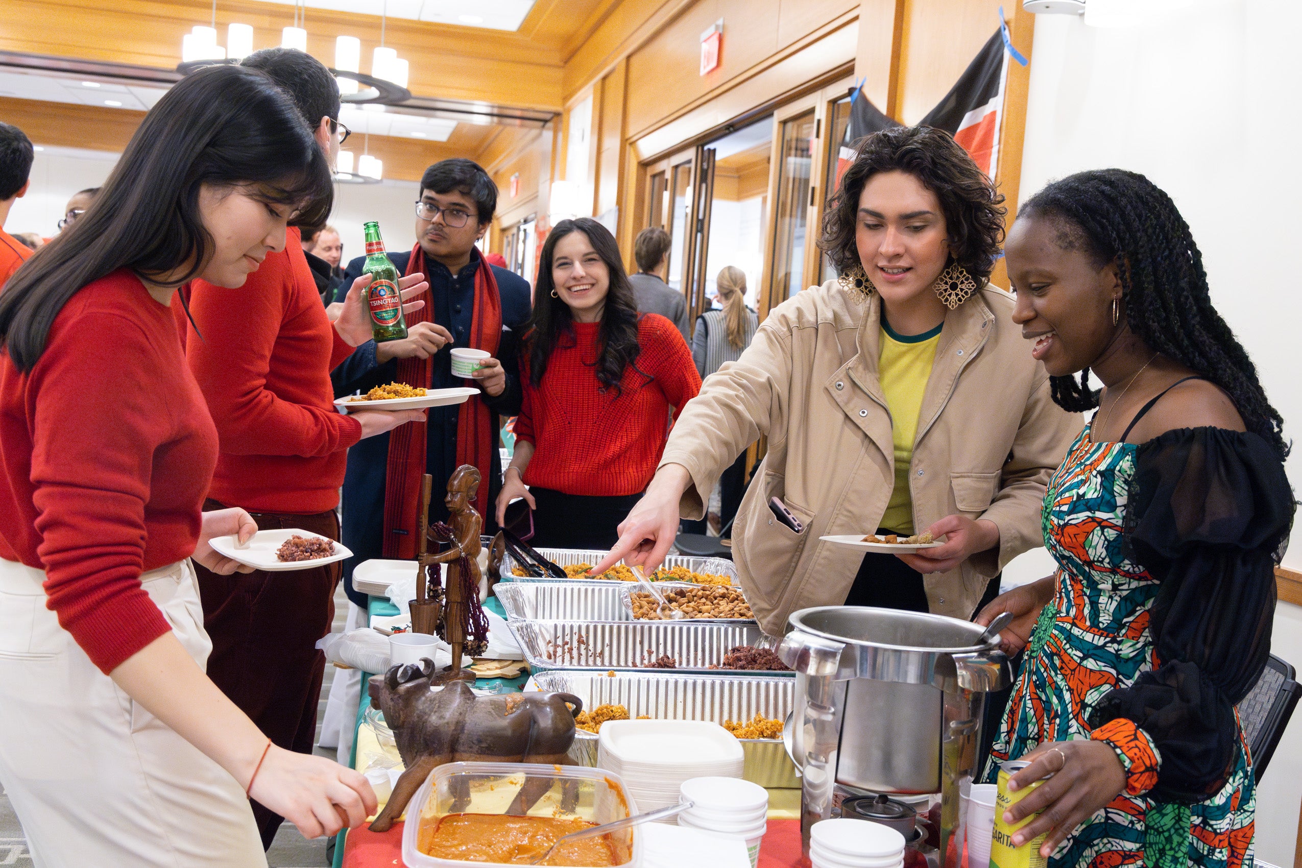 Students fill their plates with food and as they walk by a table at an international party.