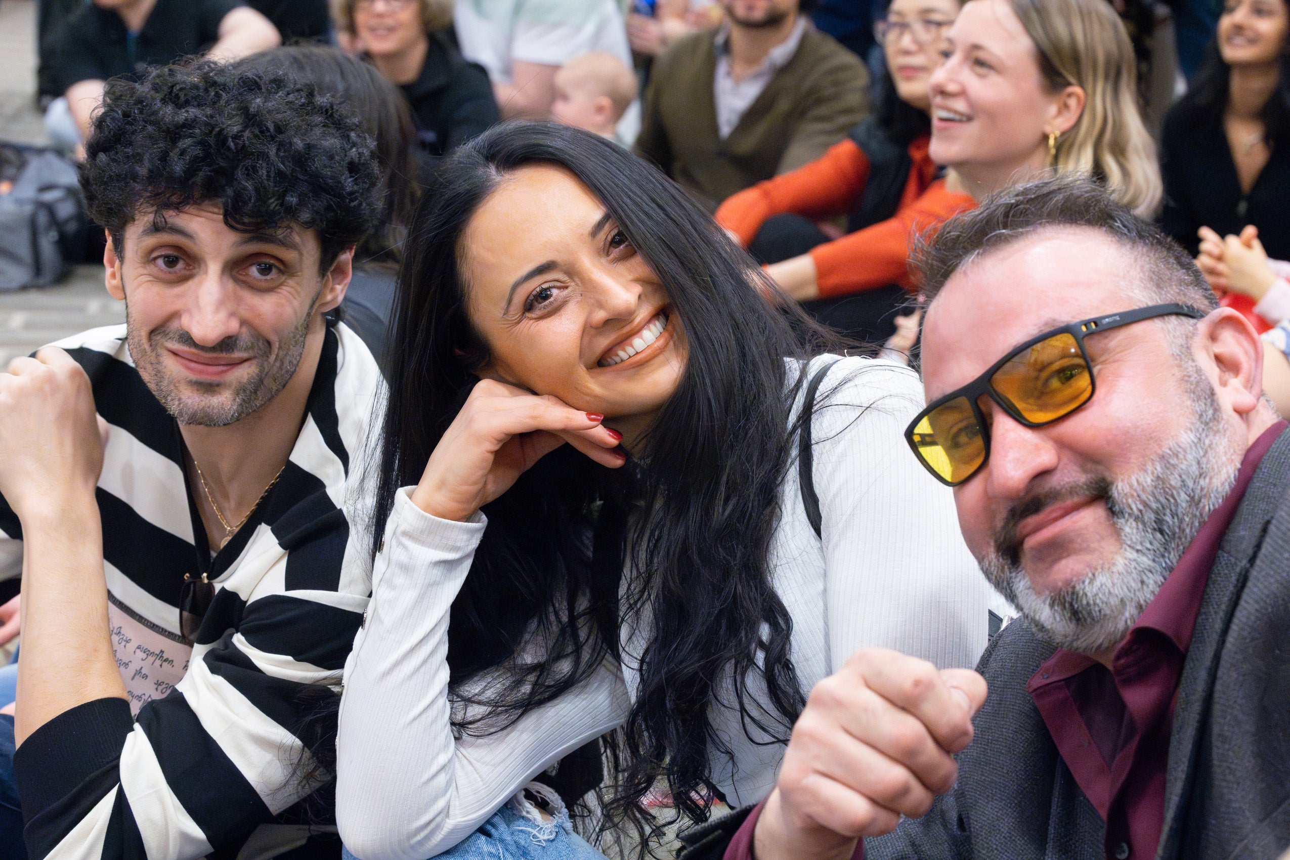 Two men and a women in a crowd at the international party