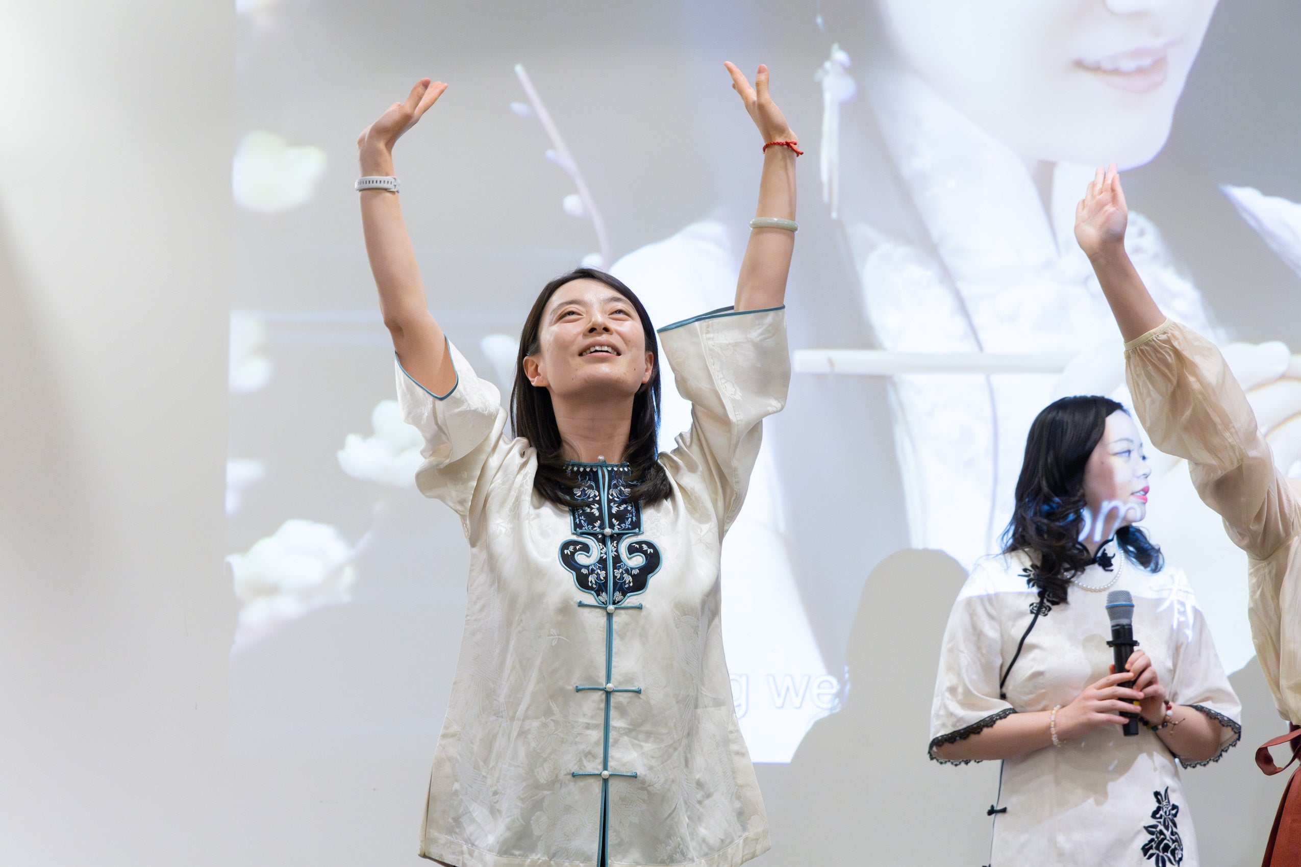A woman in traditional dress of her homeland performs a dance.