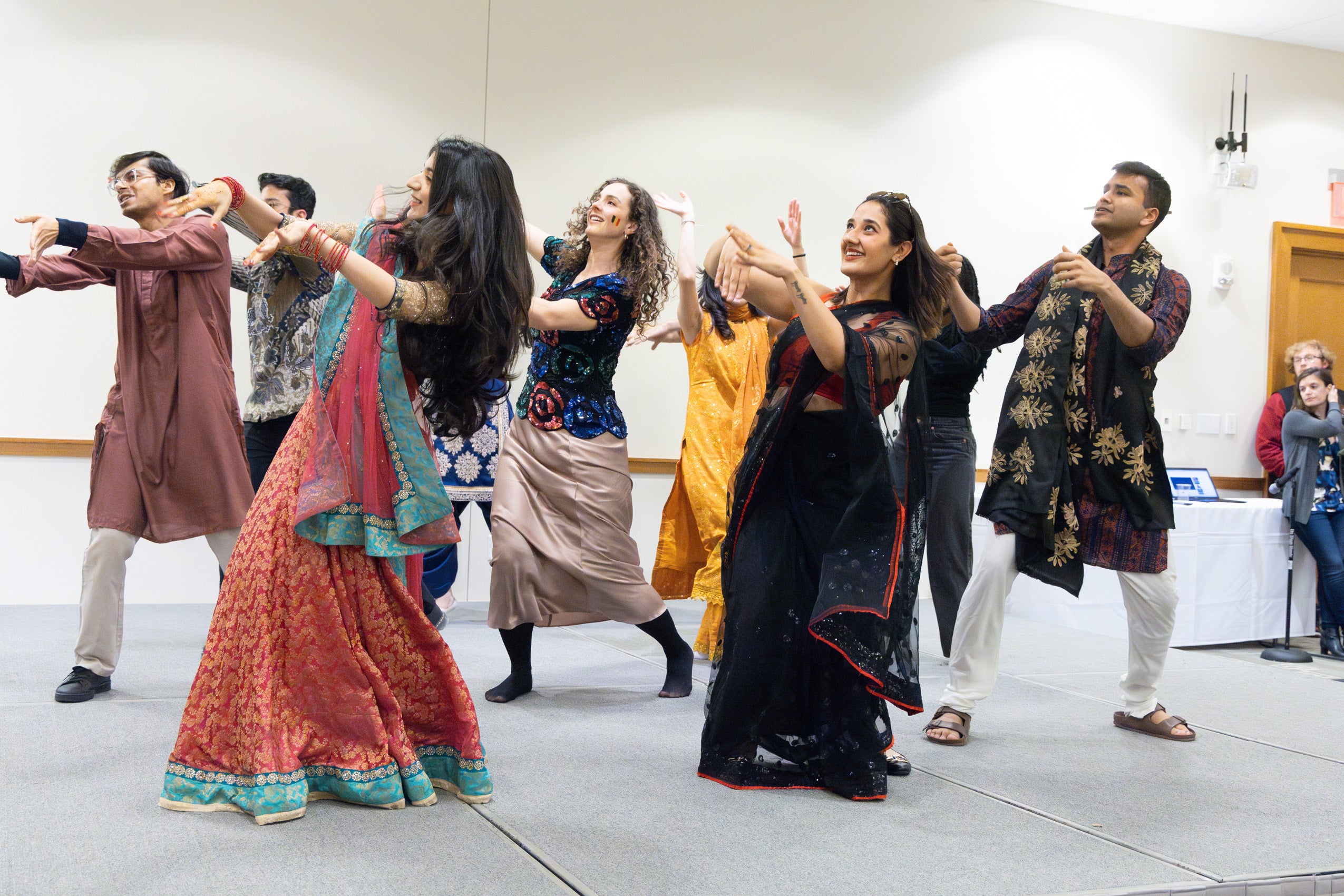 A large group of students perform a dance on stage.