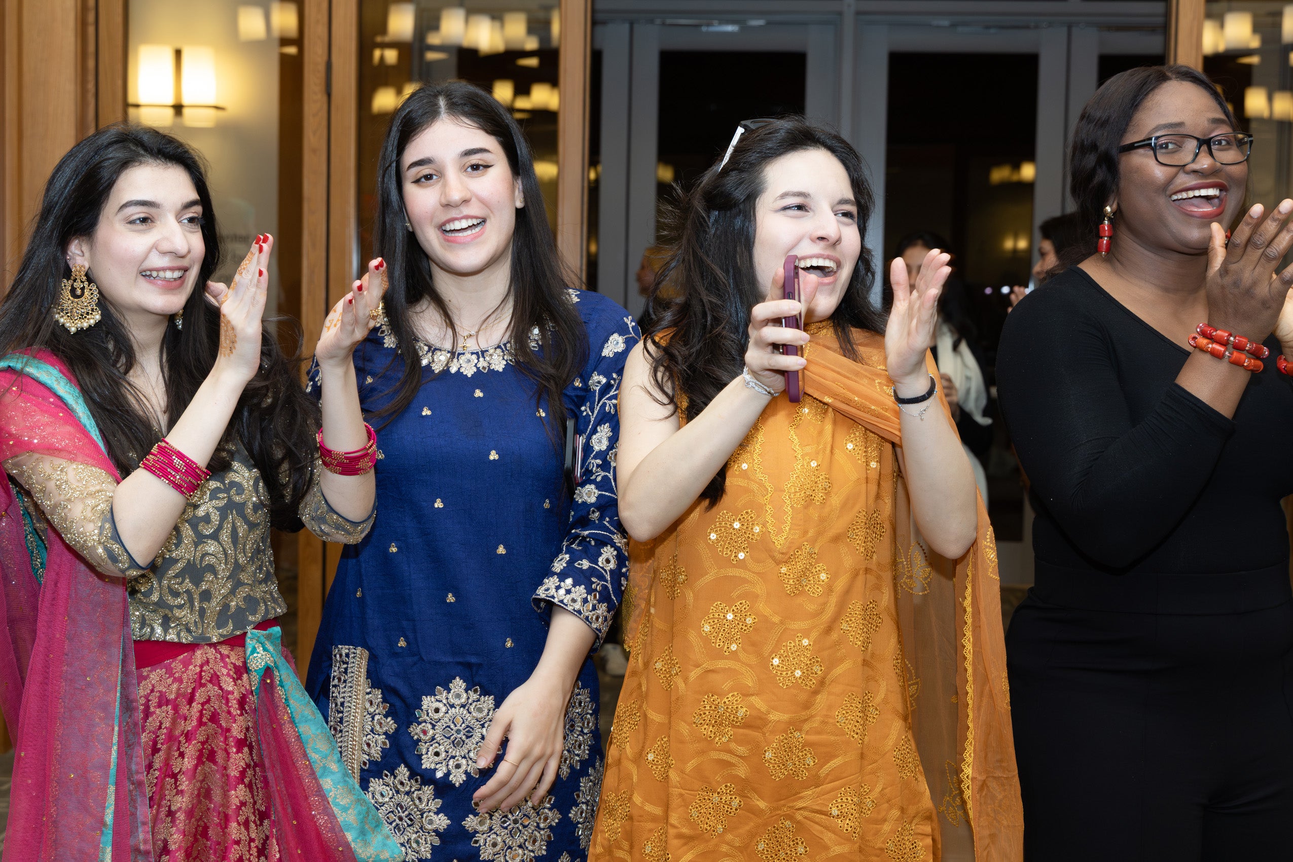 A group of women clapping joyfully.