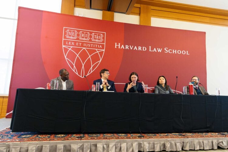 A panel of five people speak to an audience