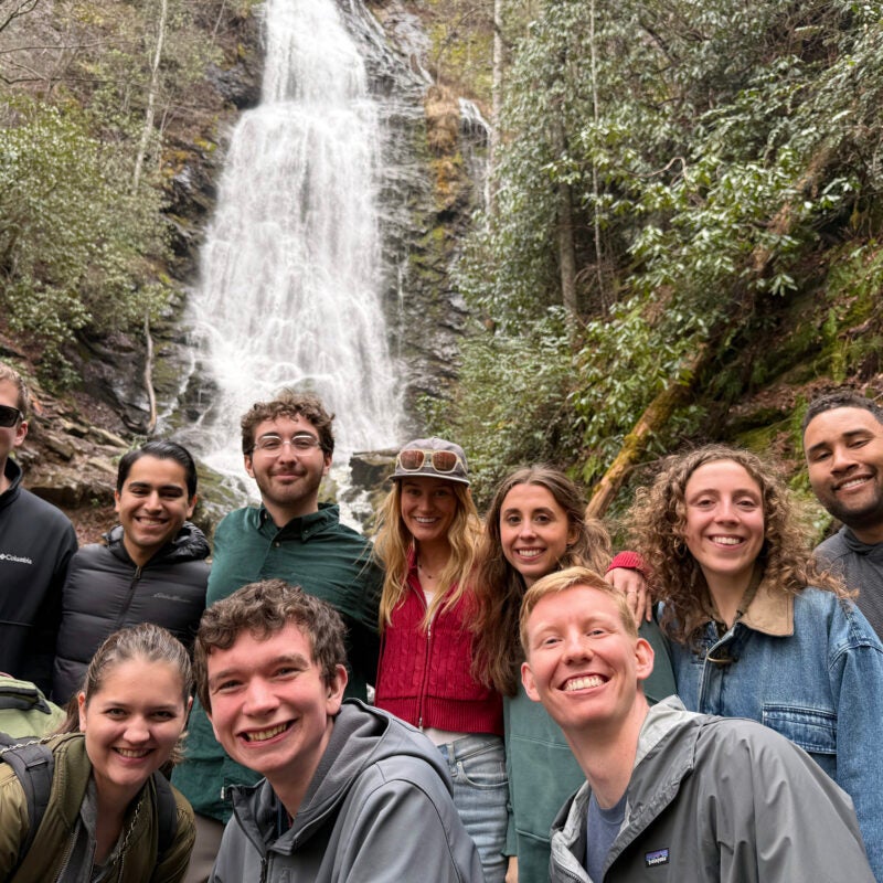Group of students posing in front of a waterfaul