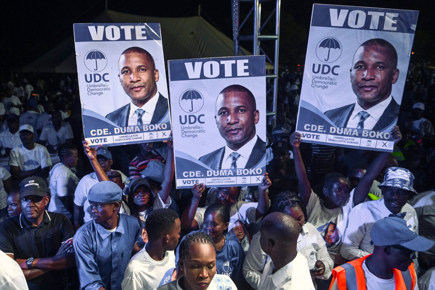 Supporters in a crowd hold banners showcasing the party's presidential candidate Duma Boko at a campain rally.