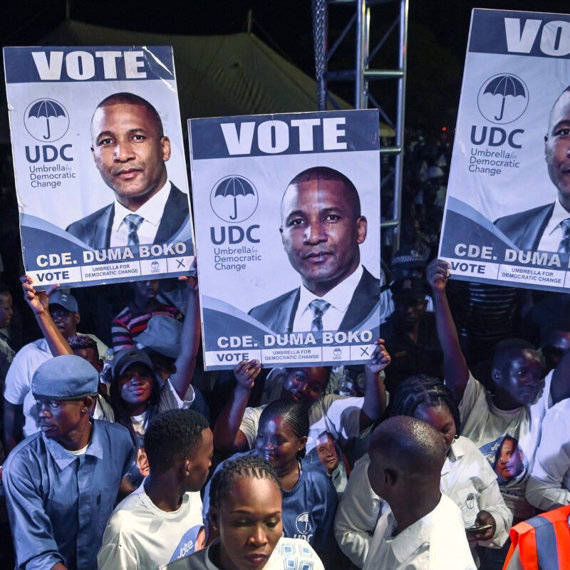 Supporters in a crowd hold banners showcasing the party's presidential candidate Duma Boko at a campain rally.