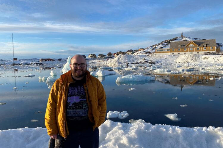 Shay Elbaum standing in front of a snowy lake.