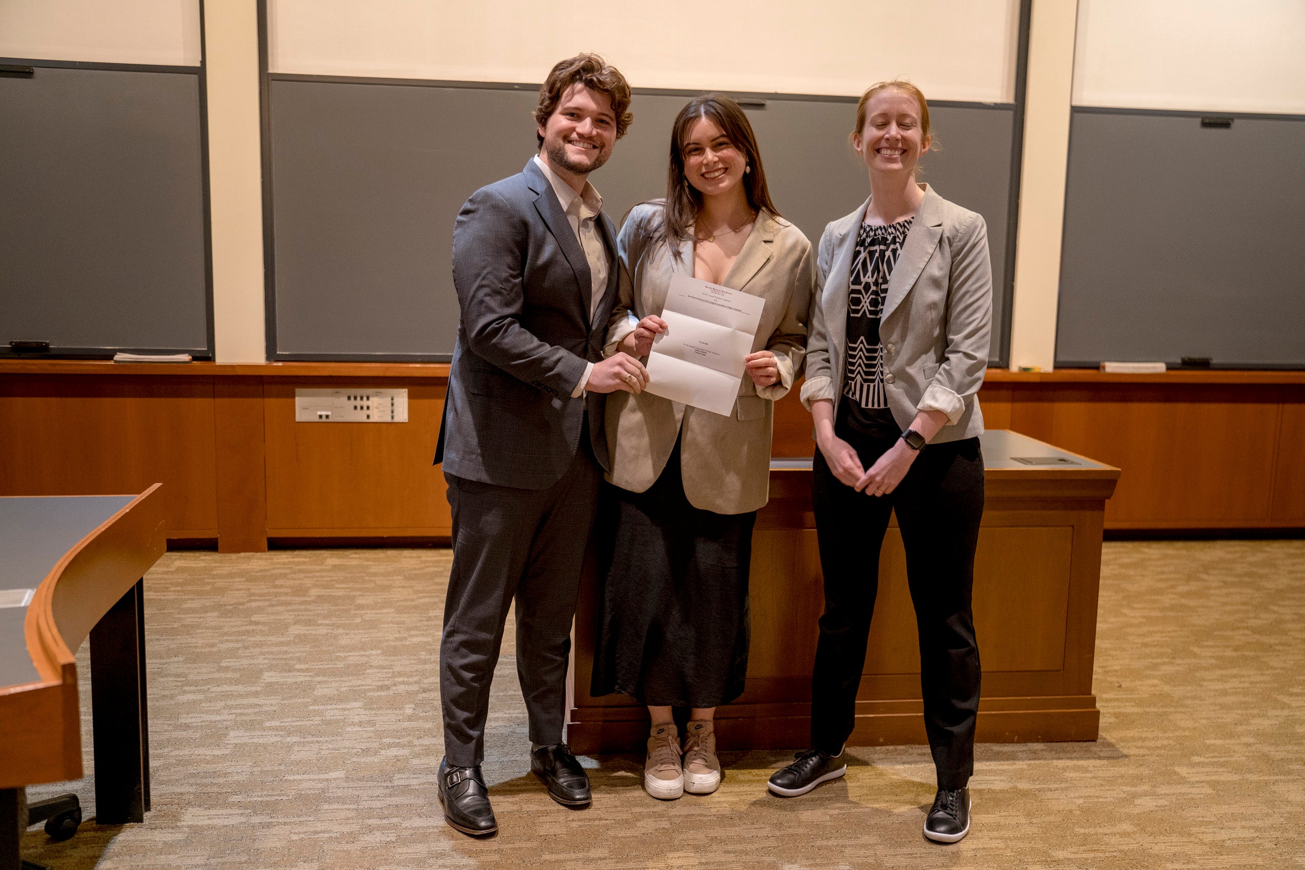 Students holding a paper which announces a prize