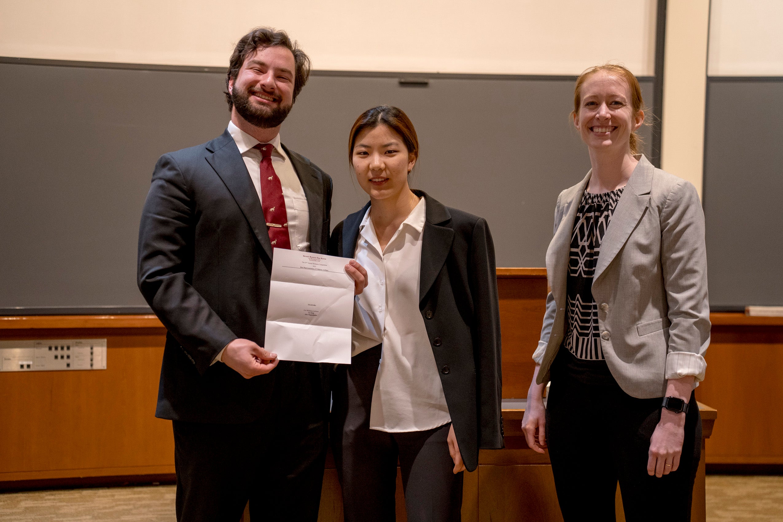 Students holding a paper which announces a prize.