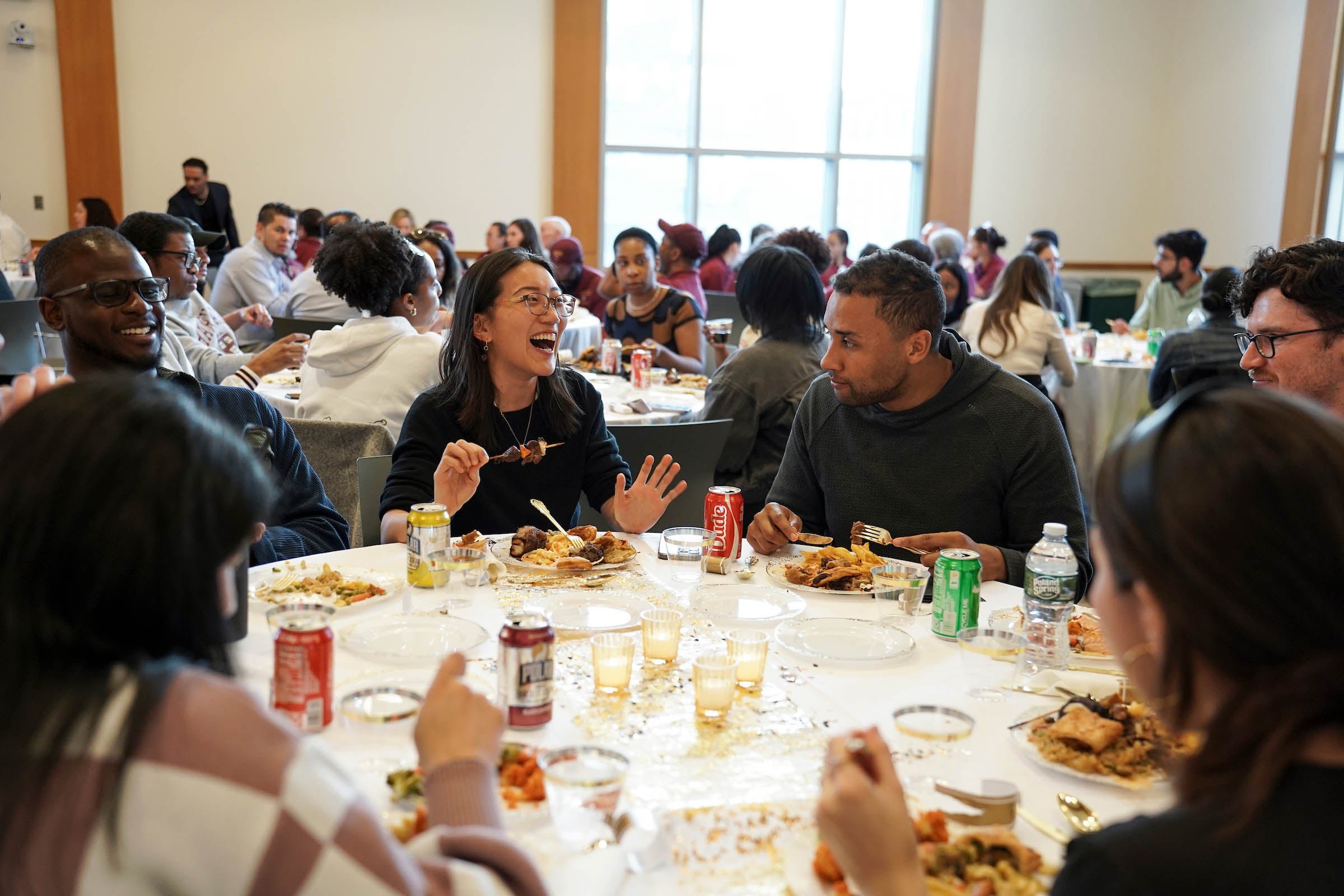 Dinner attendees smiling and laughing in conversation.