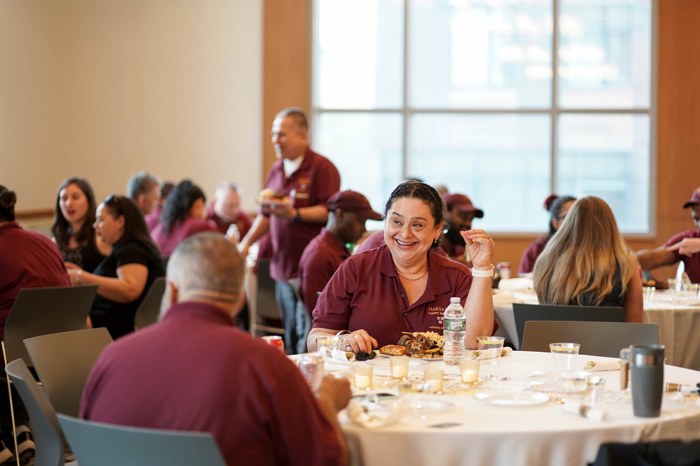 A custodial staff member smiles at the dinner table.