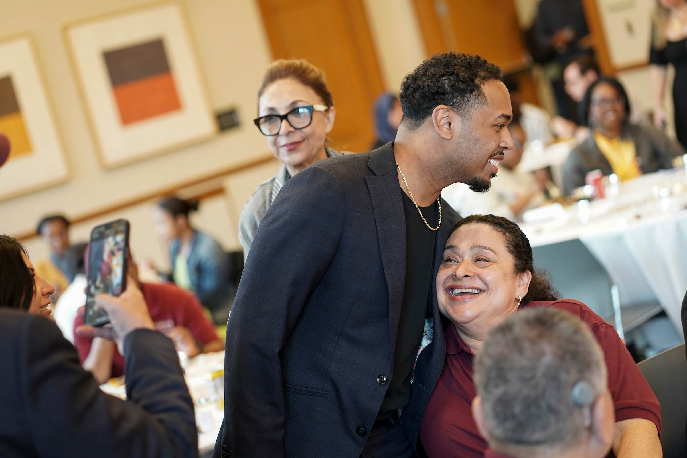 Rehan Staton embraces a member of the custodial staff.