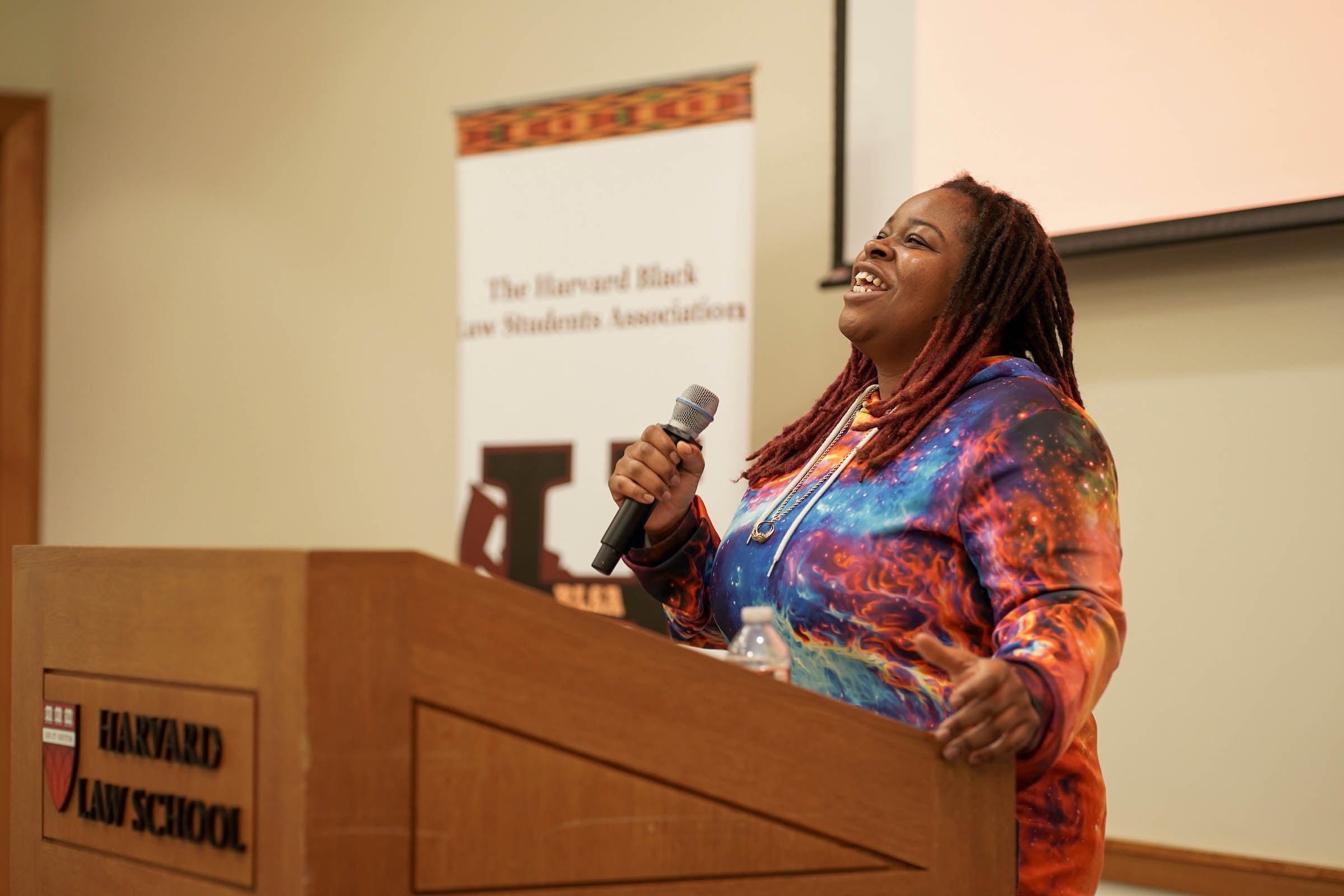 Spoken word poet Tru Kwene performs from the podium.