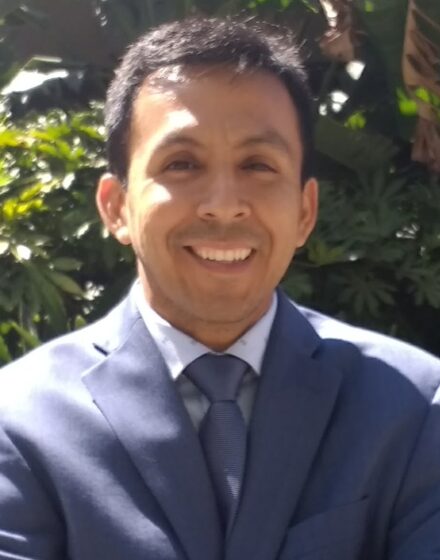 Librarian Juan Andres wearing a suit and smiling.