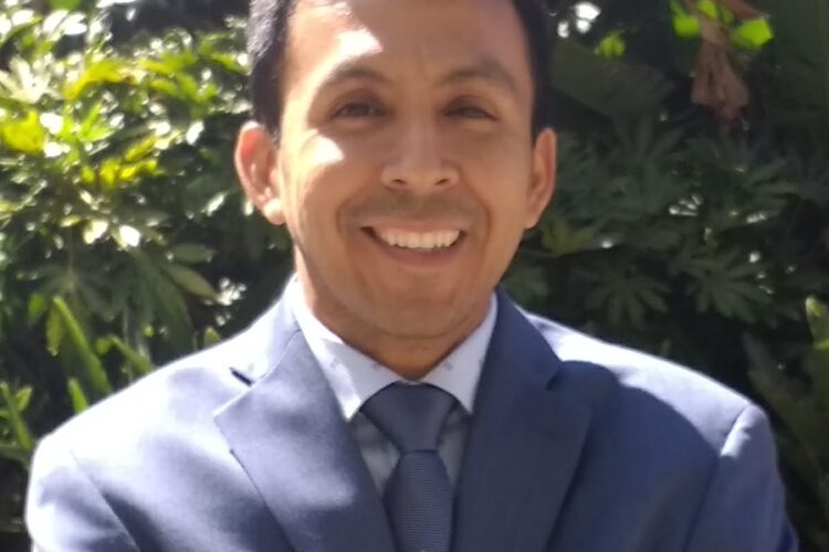Librarian Juan Andres wearing a suit and smiling.