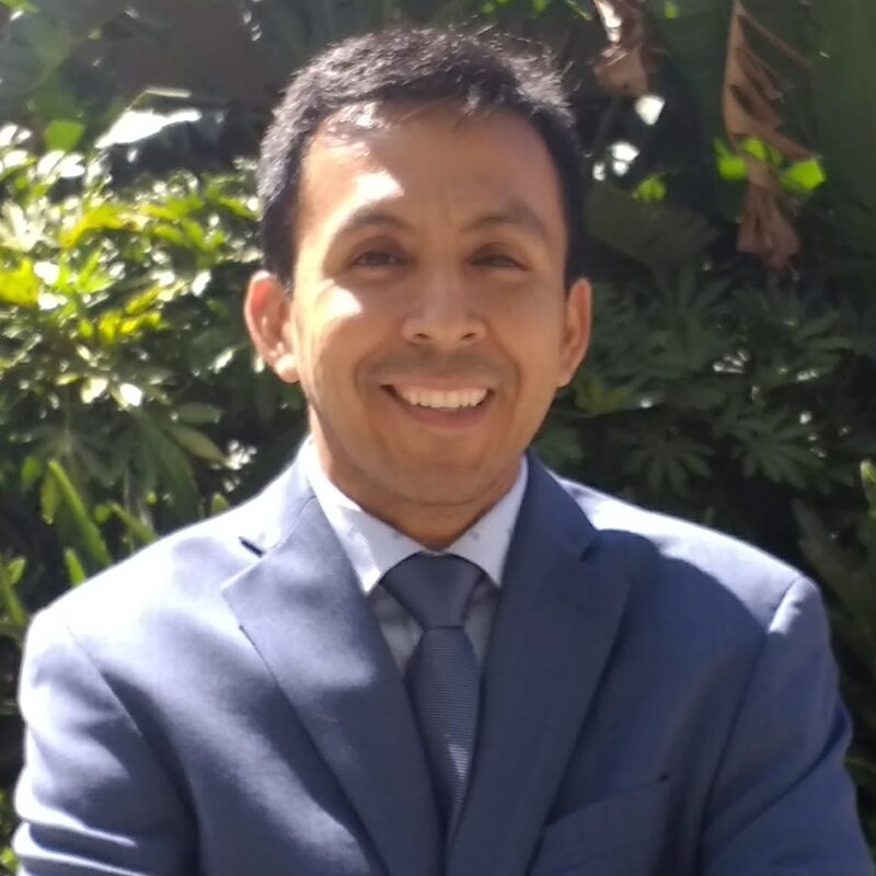 Librarian Juan Andres wearing a suit and smiling.