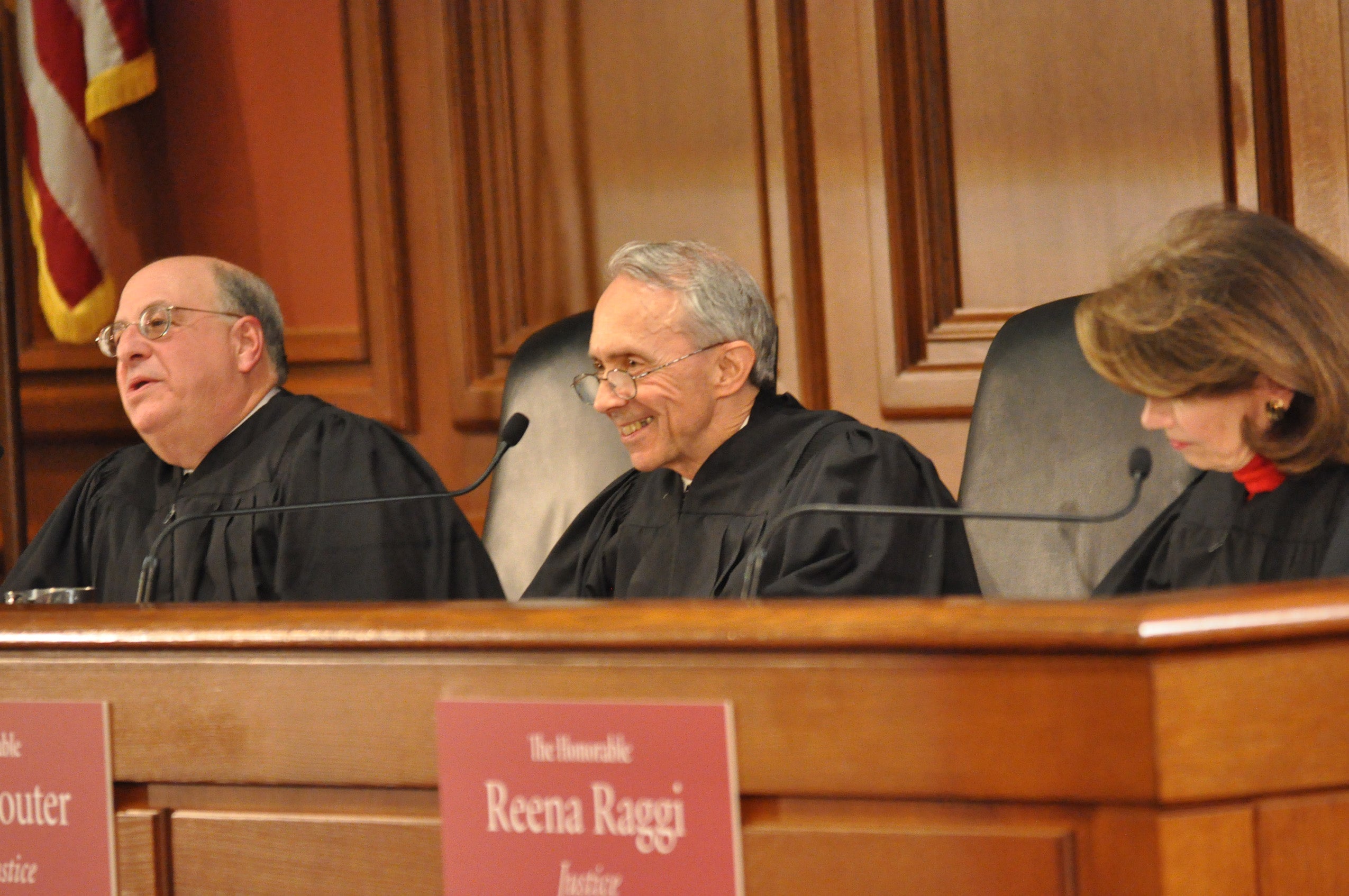 Three judges in robes sitting behind the bench.
