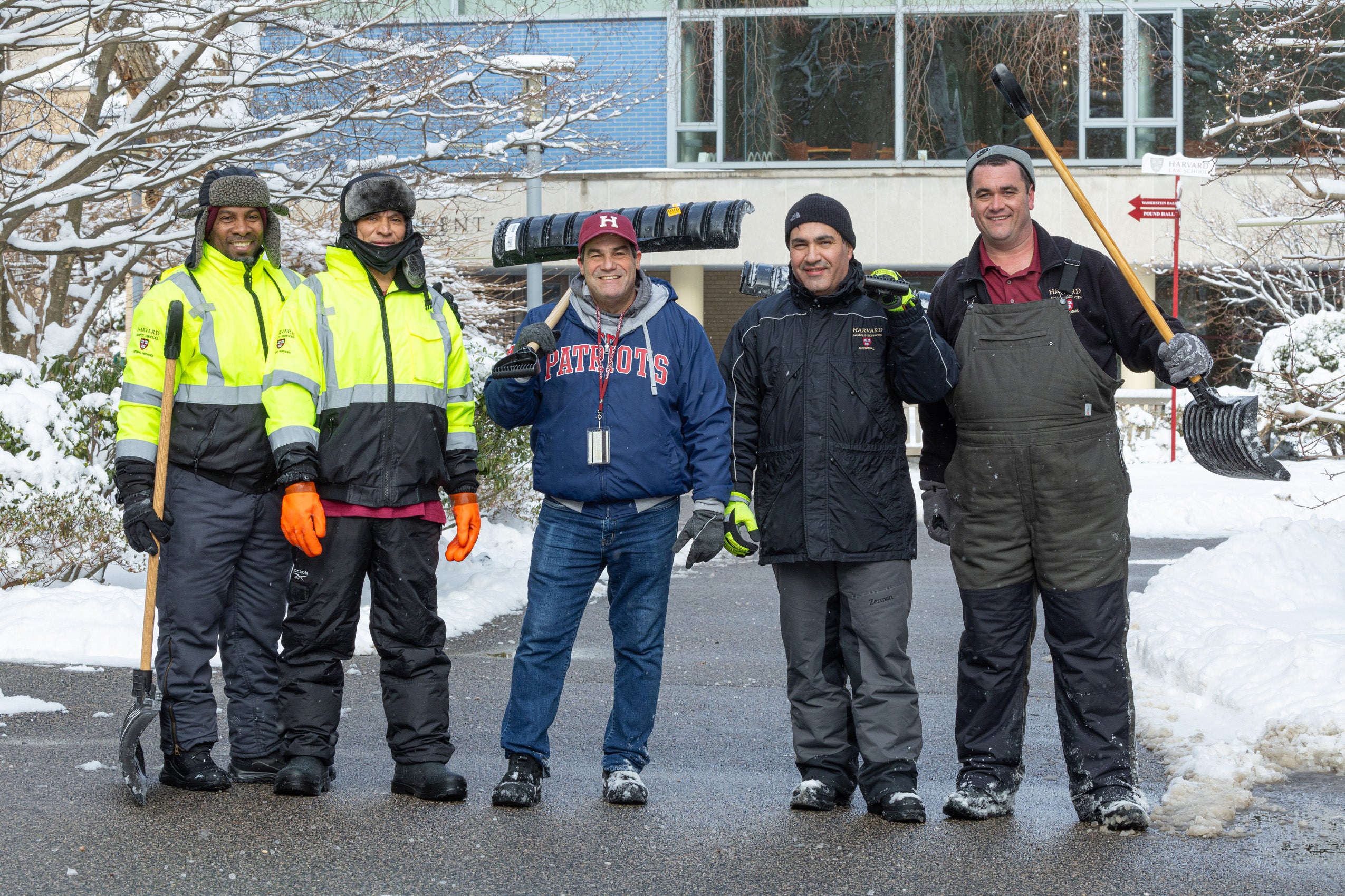 Five men with shovels pose on campus after a snow storm.