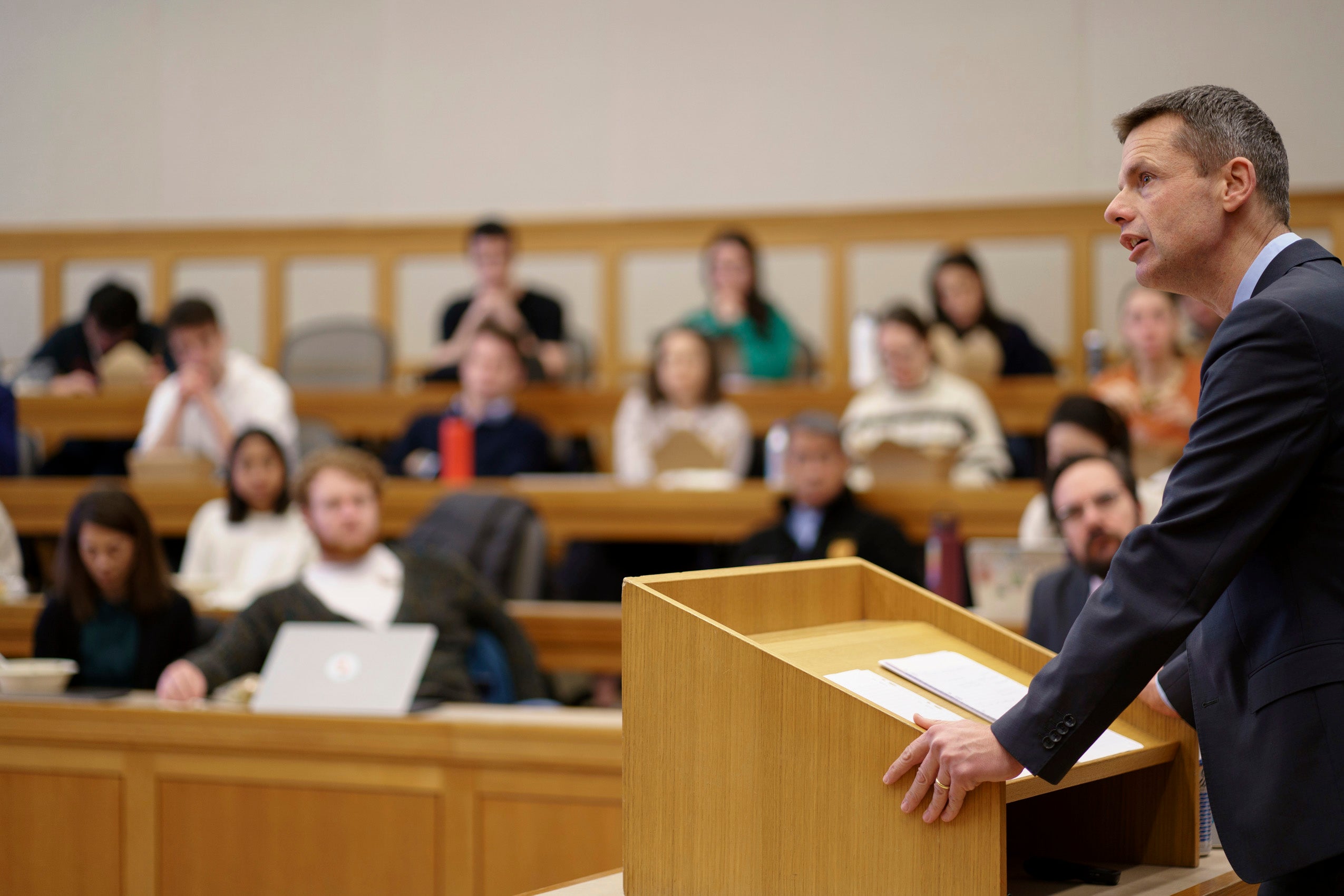 A man at a podium in front of a classroom.