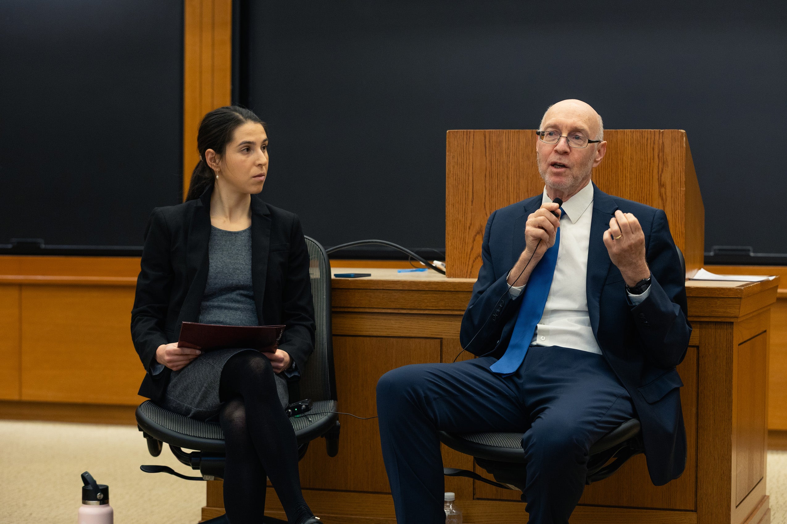A man speaks in the front of a classroom.