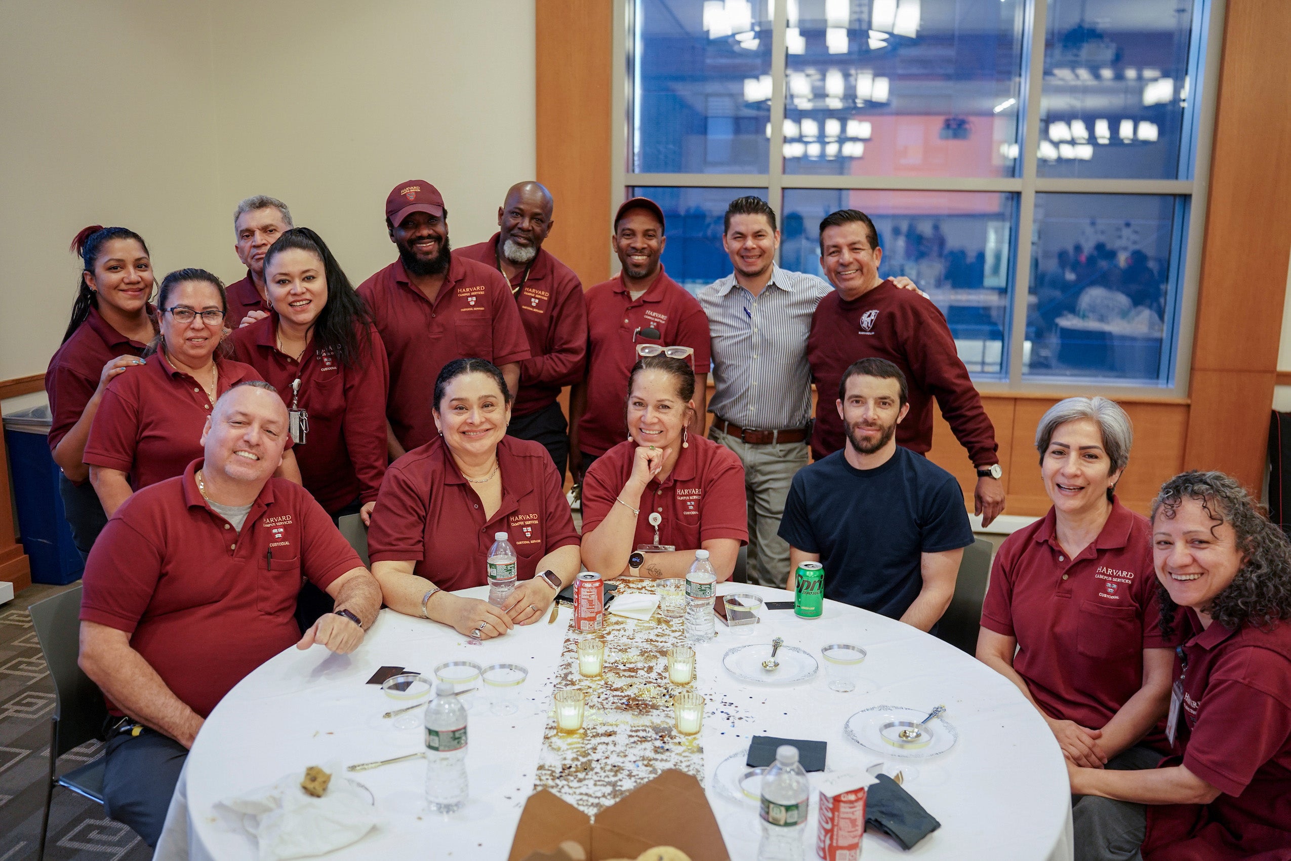 A group of people wearing crimson shirts around a take pose for a photo.