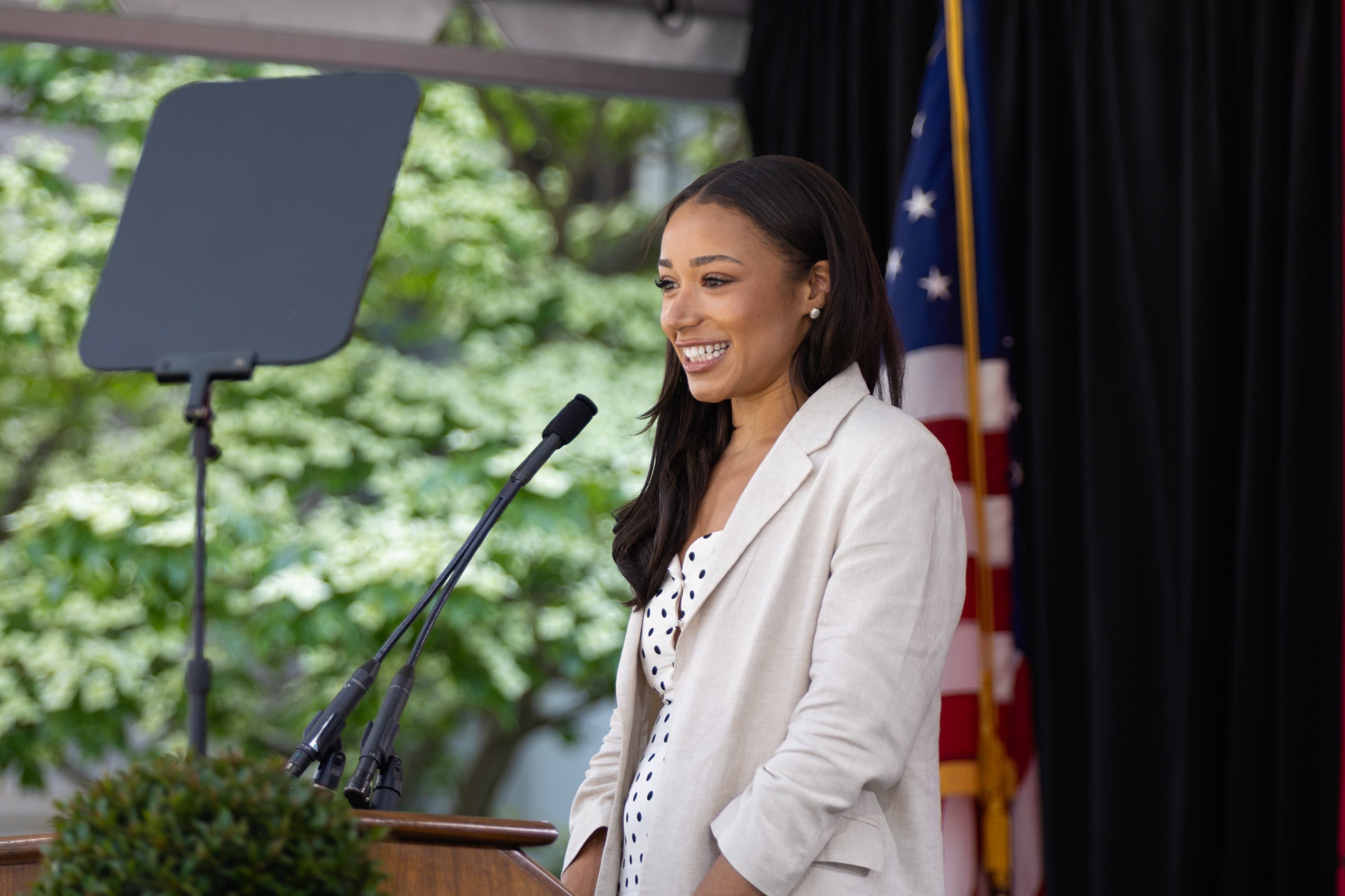 A woman standing and speaking at a podium