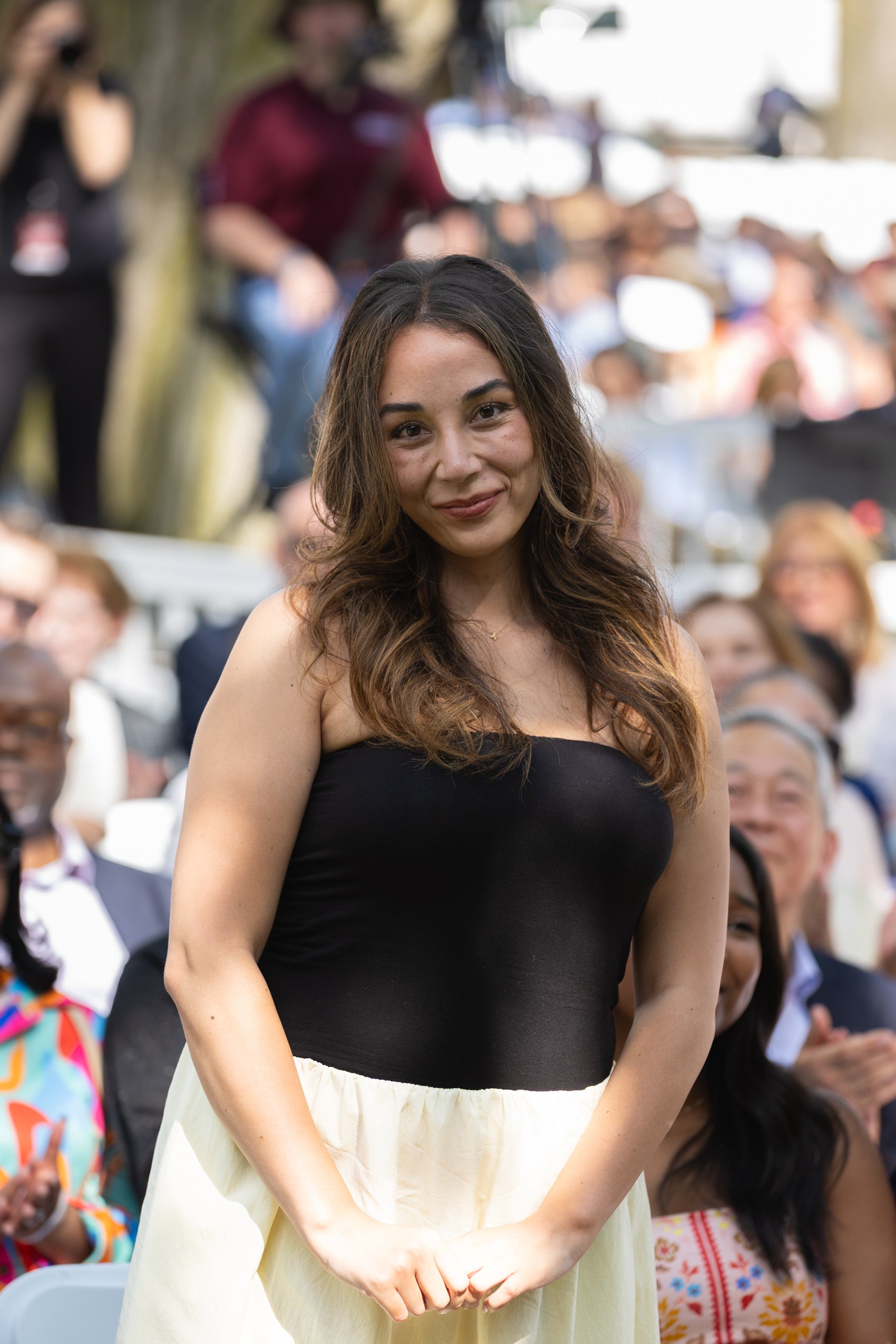 A woman standing in front of a crowd.