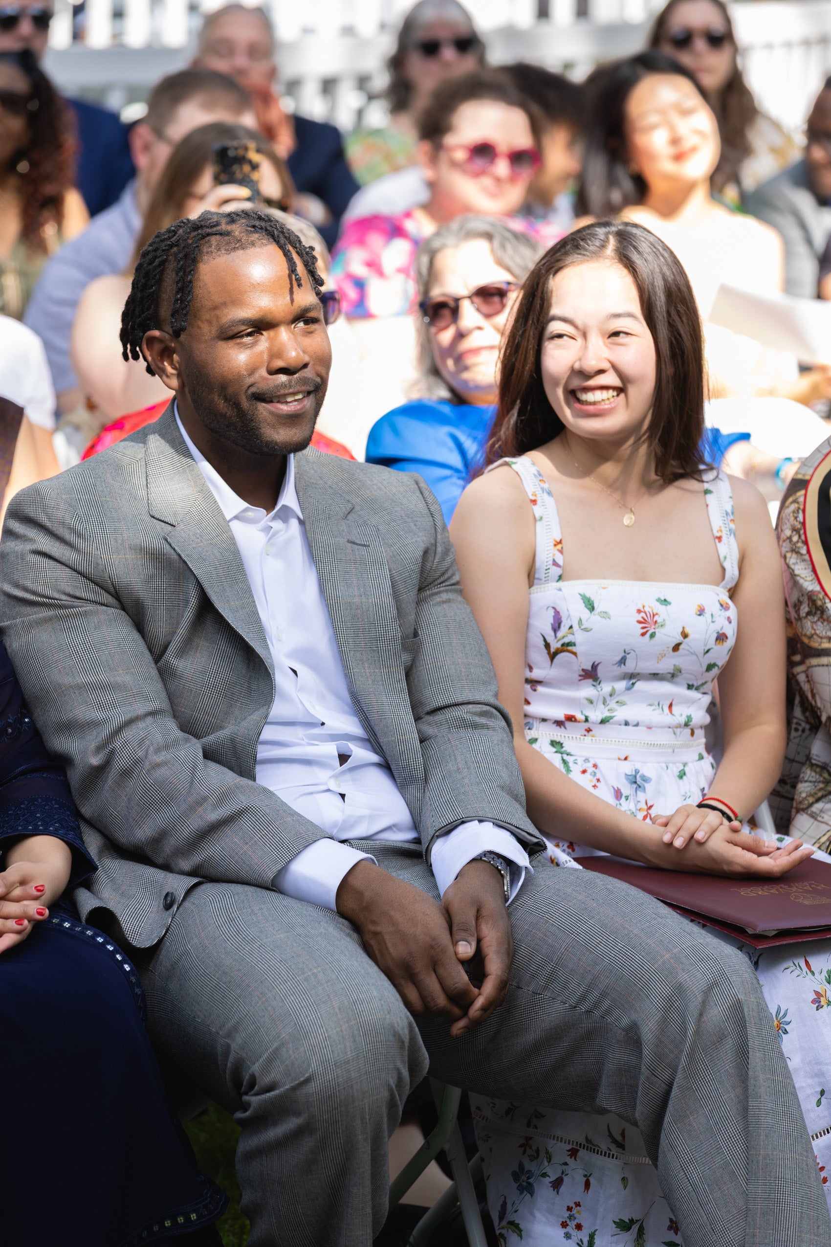 A man sitting in the audience smiles.