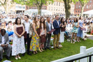 A group of people standing up in a row in the front of an audience.