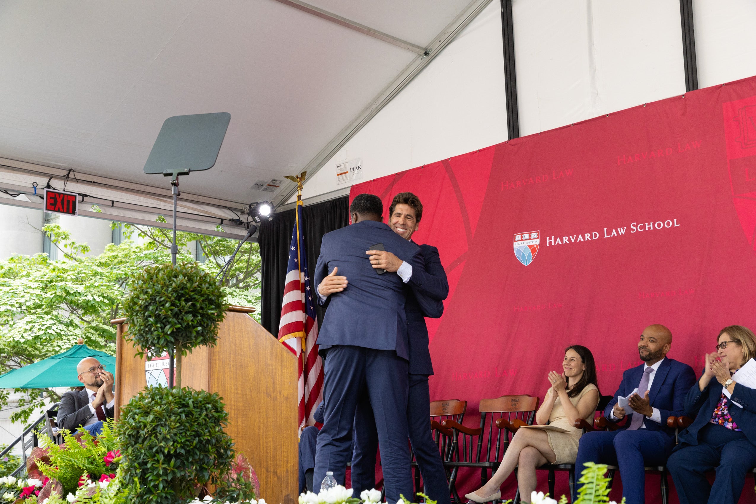 Two men hug on stage.