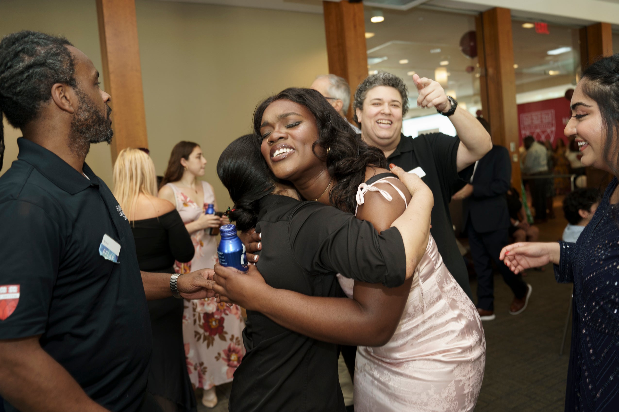 Two women embrace as others watch