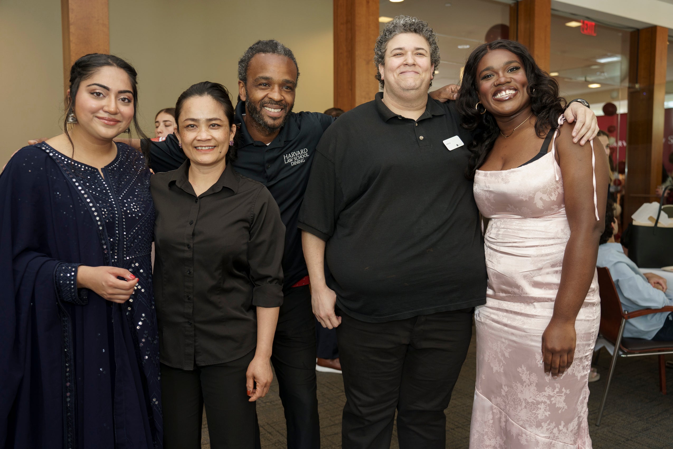 A group of five people standing together and smiling