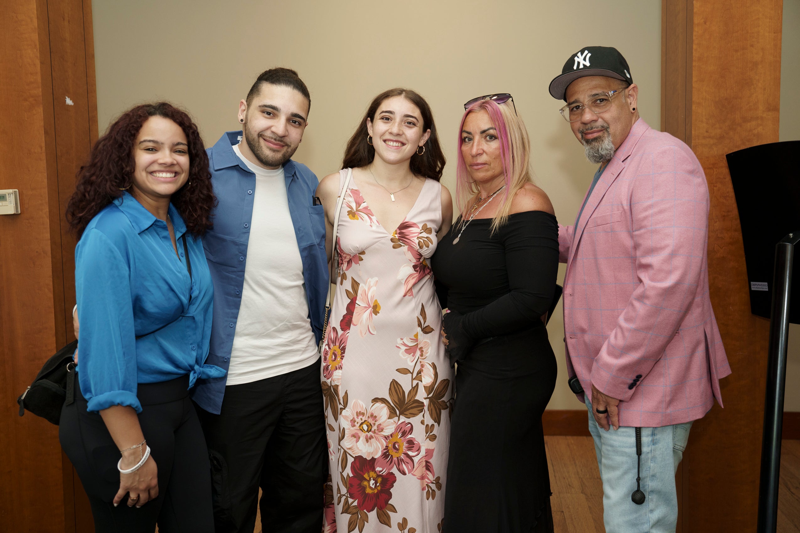 A group of five people standing together and smiling