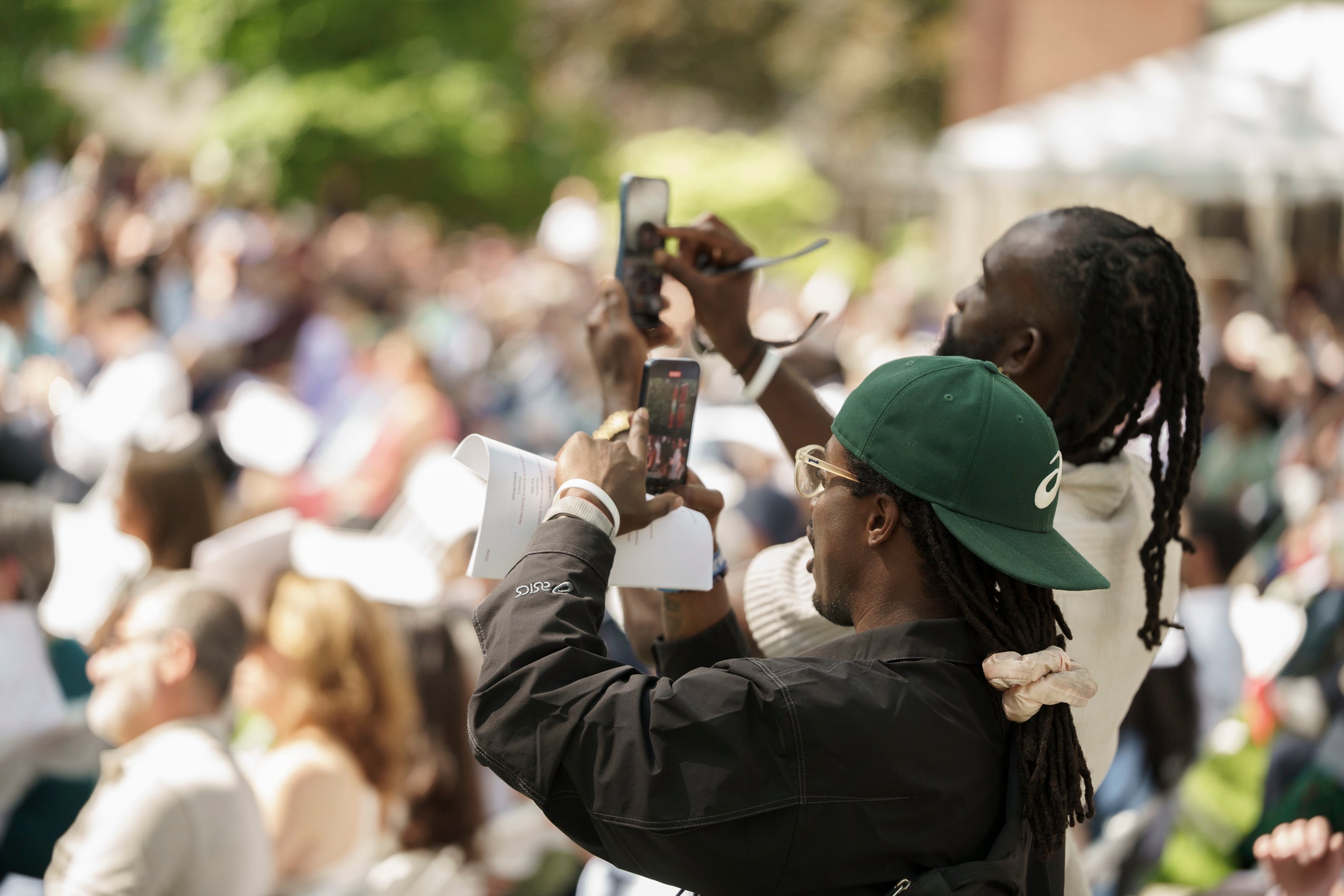 Two people holding phone up taking photos