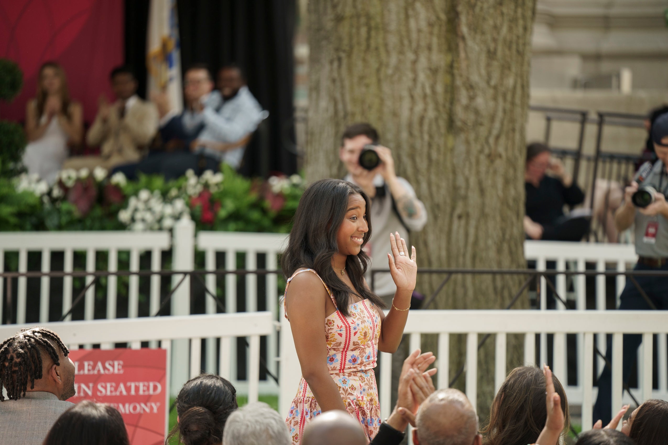A woman waving to the audience