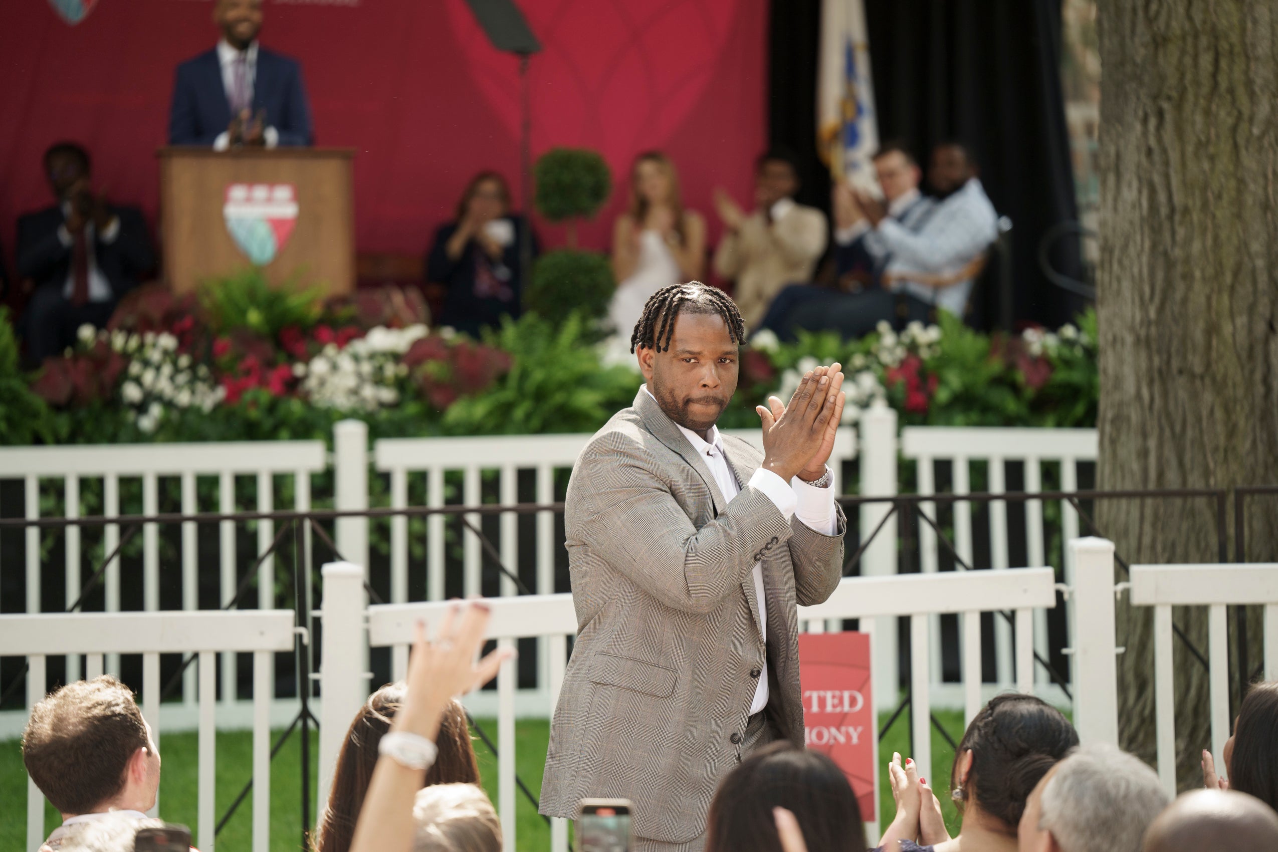 A man looking into the audience and clapping