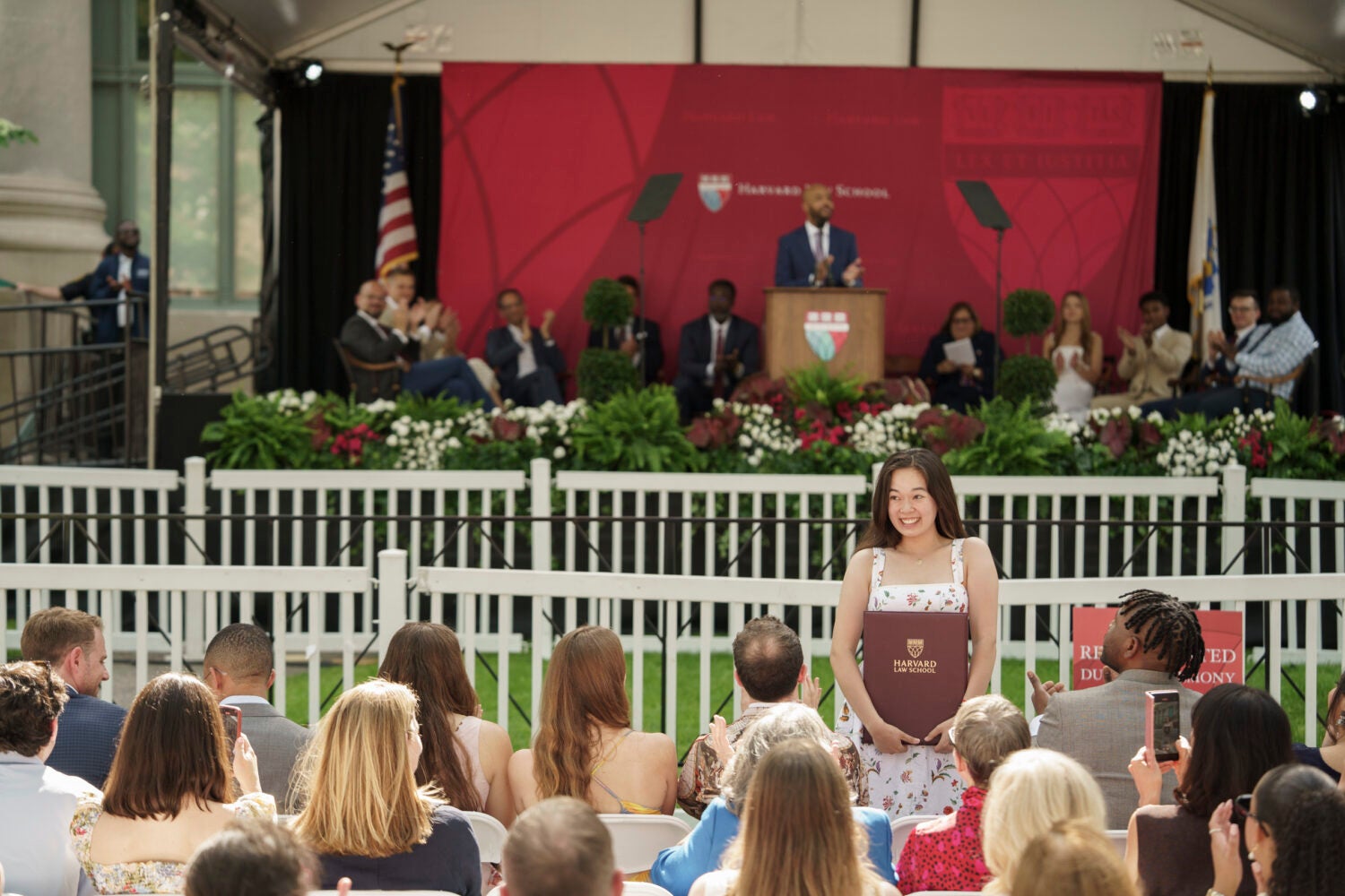 A woman holding an award and smiling at the audience