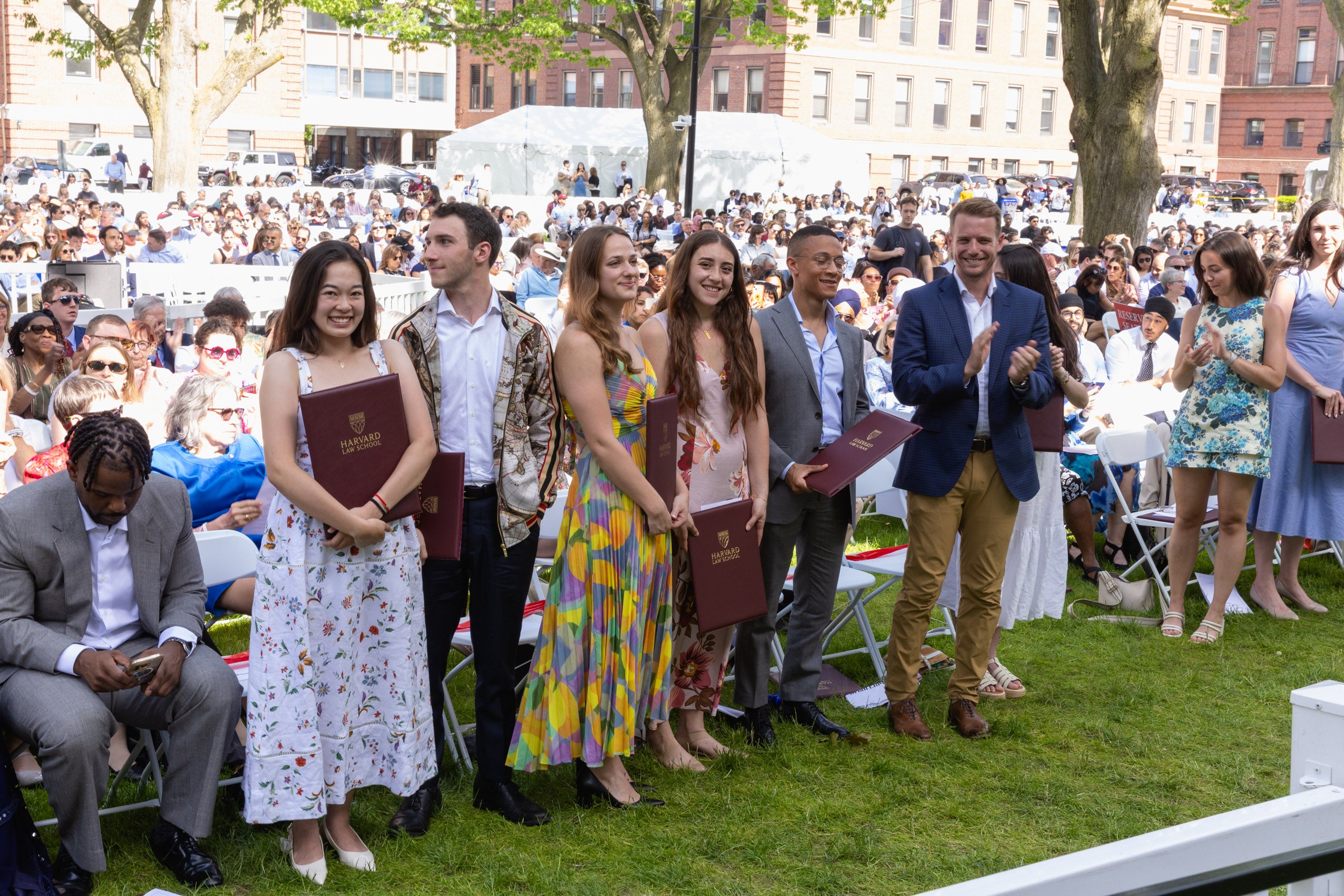 A group of people standing in front of an audience, holding awards