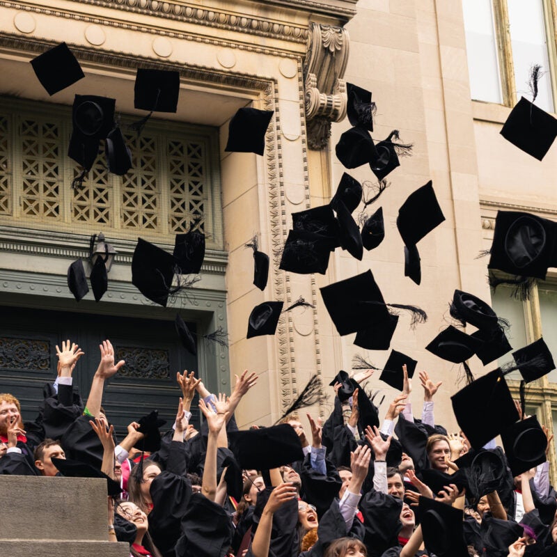 A group of graduates throwing their caps in the air.