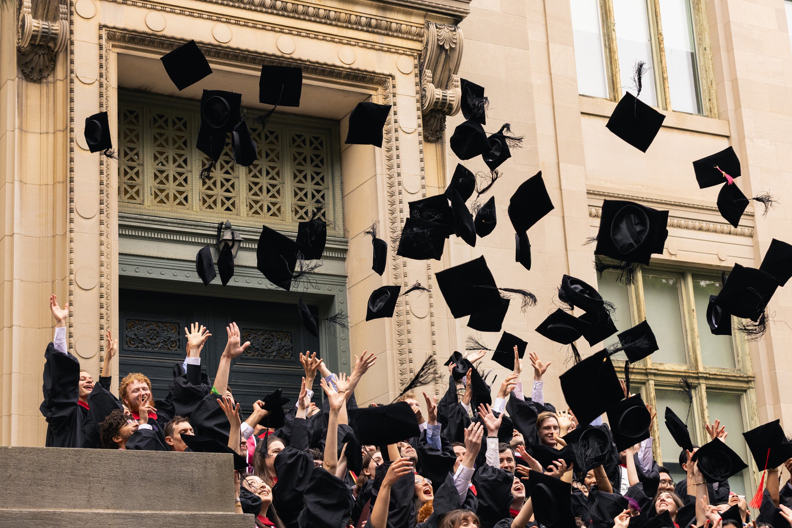 A group of graduates throwing their caps in the air.