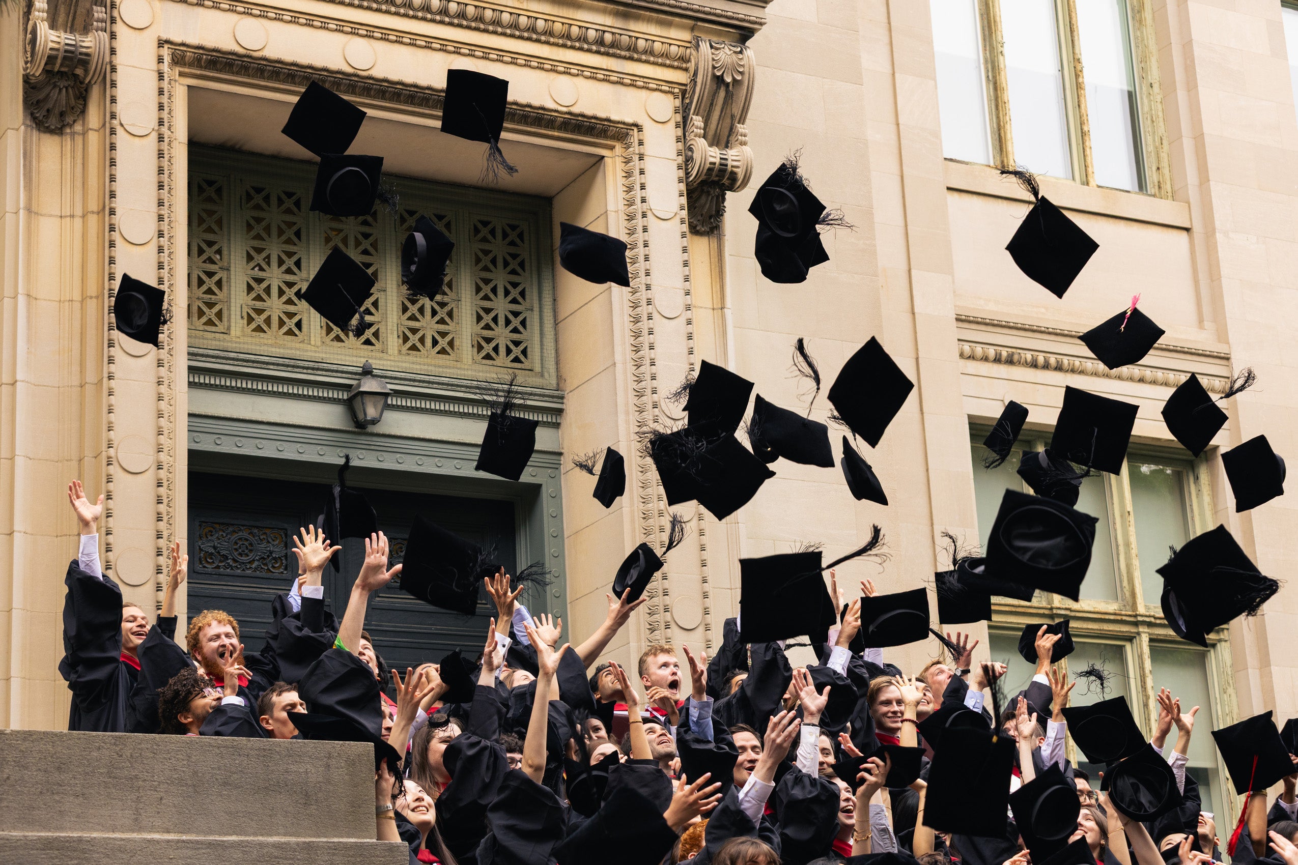 A group of graduates throwing their caps in the air.