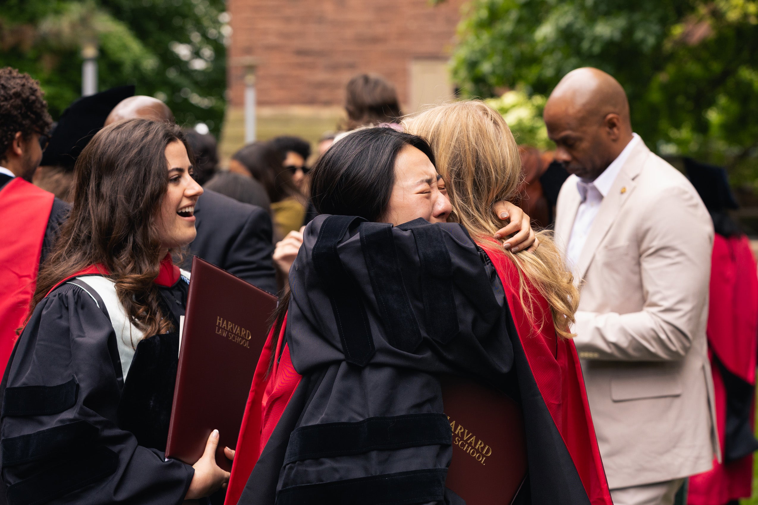 Two graduates share an emotional embrace