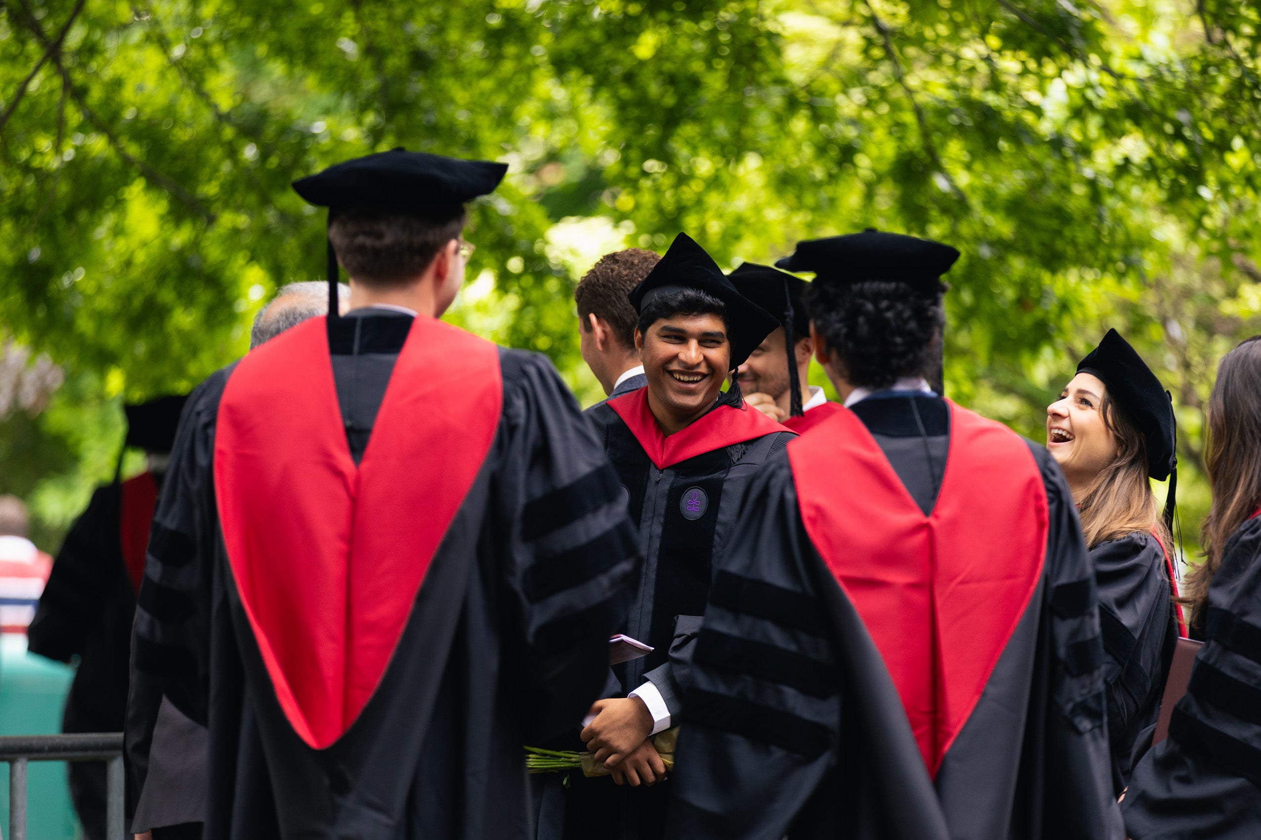 Graduates standing together, smiling and chatting