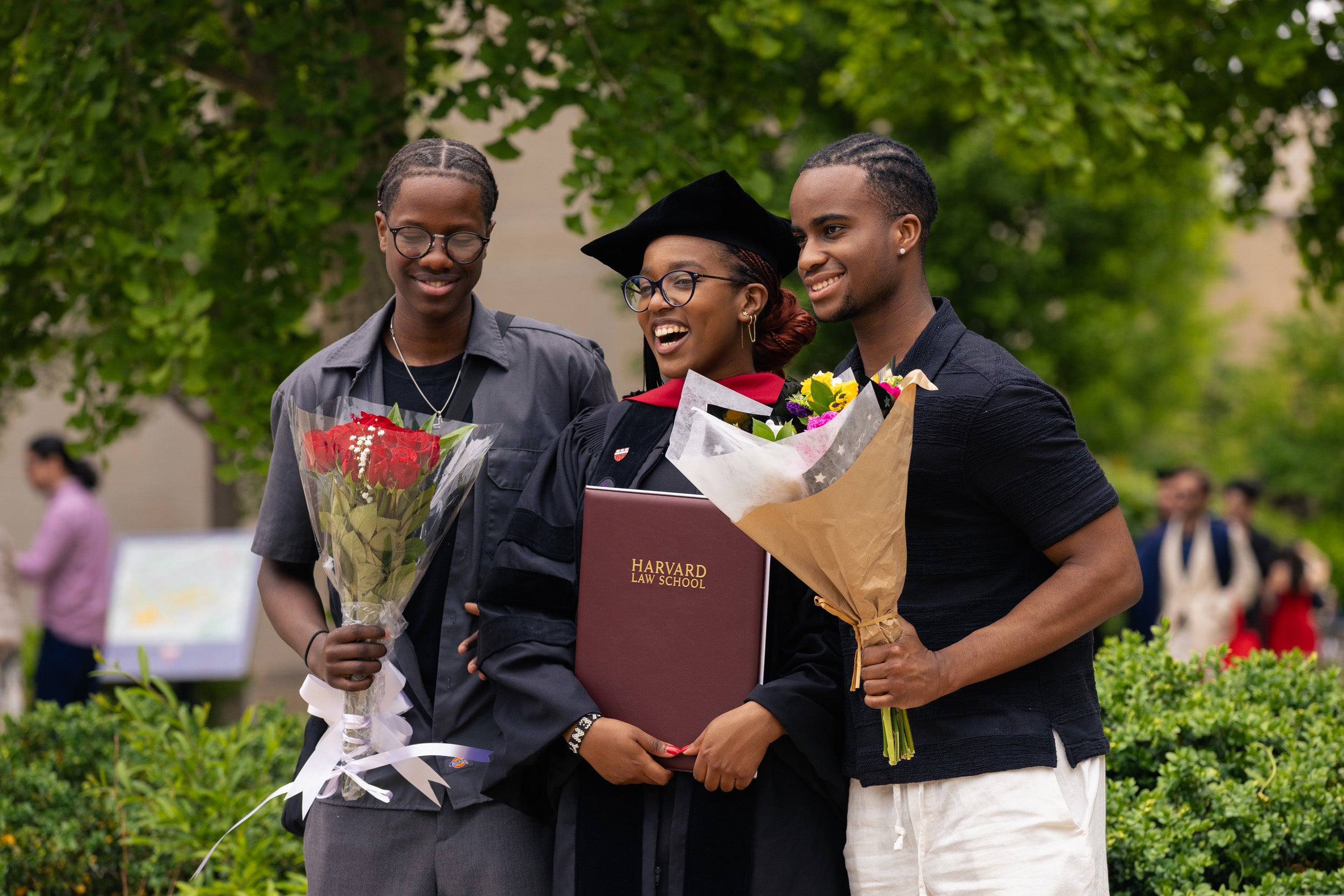 A graduate posing with her degree and her family