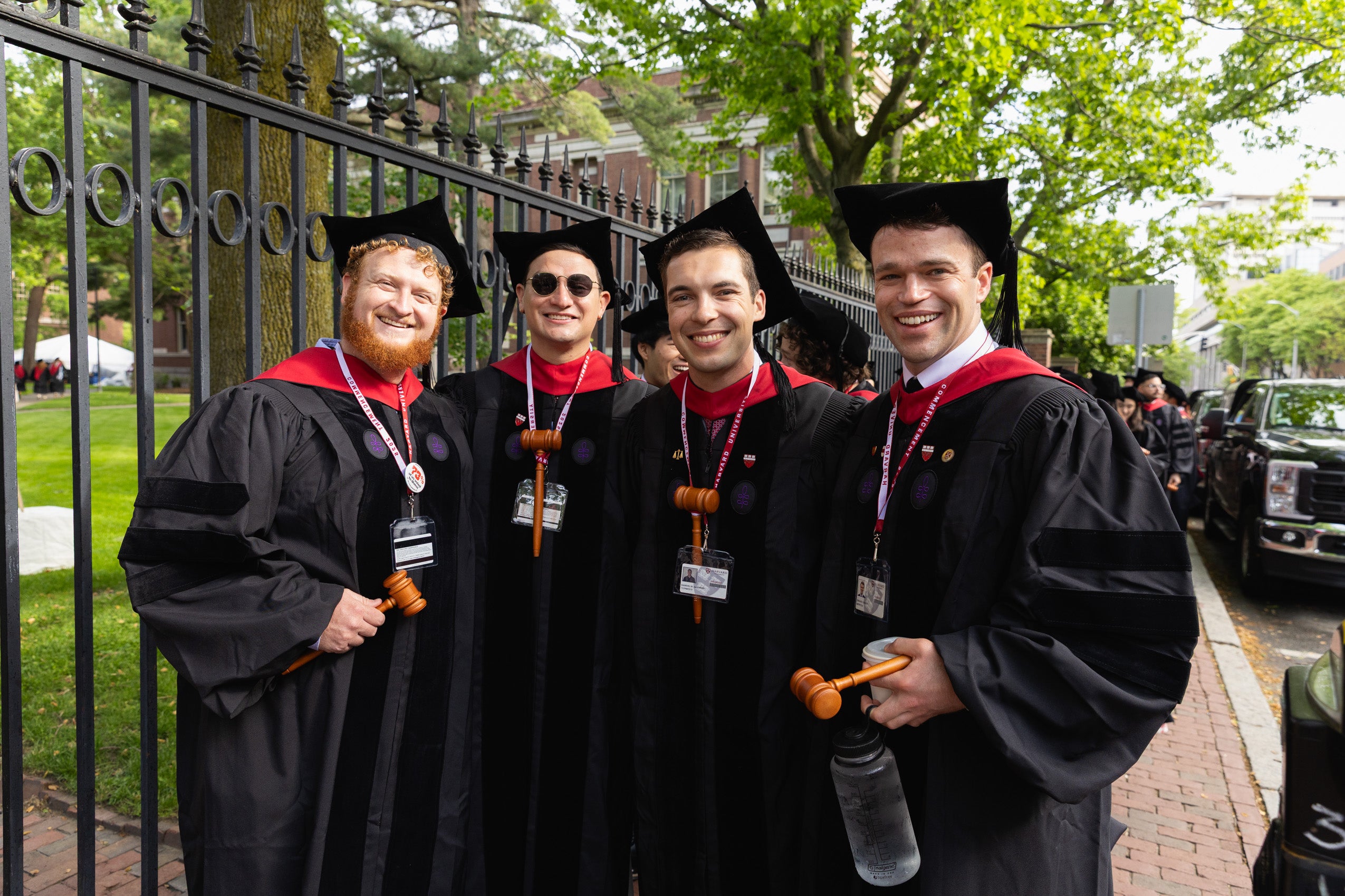 A group of four graduates posing together and smiling