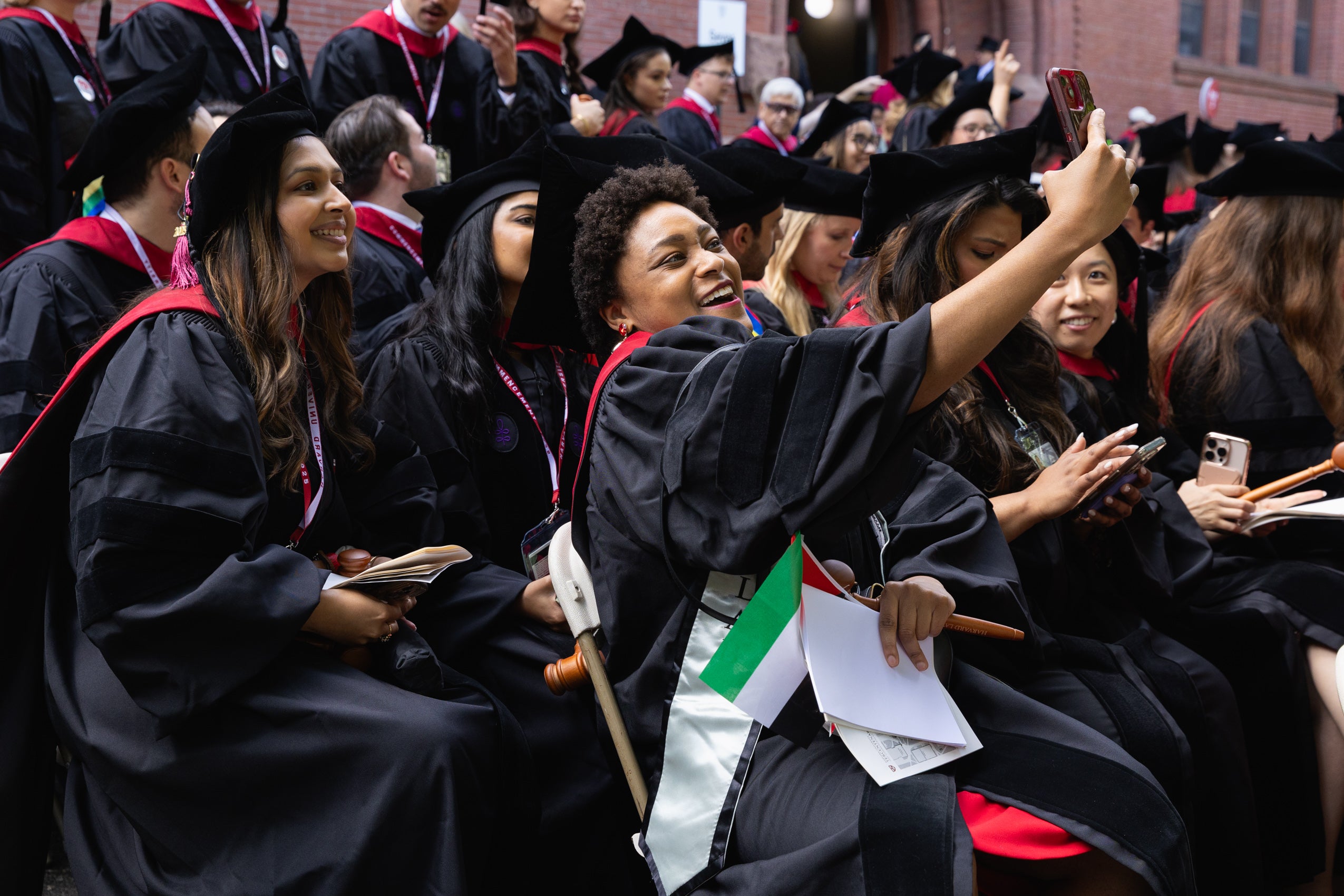 A graduate takes a selfie with fellow classmates